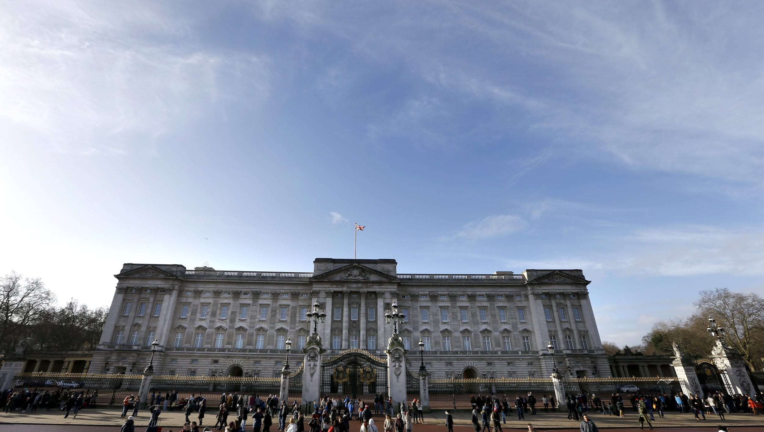 Tourists walk around Buckingham Palace in London on  Tuesday.
