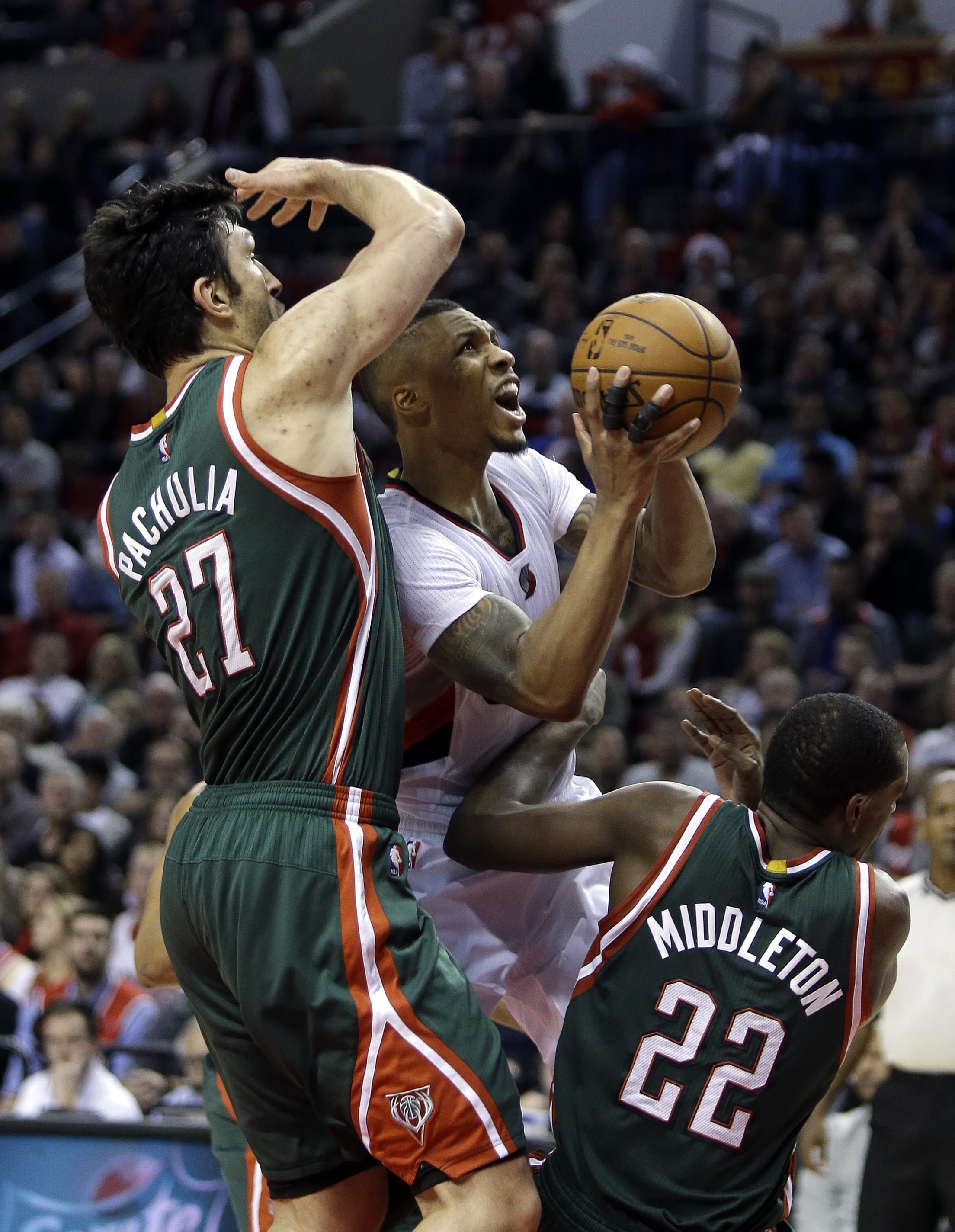 Don Ryan/Associated Press
Portland guard Damian Lillard, middle, drives to the basket between Milwaukee Bucks' Zaza Pachulia, left, and Khris Middleton during the second half  Wednesday. Lillard led the Trail Blazers in scoring with 29 points as they defeated the Bucks 104-97.