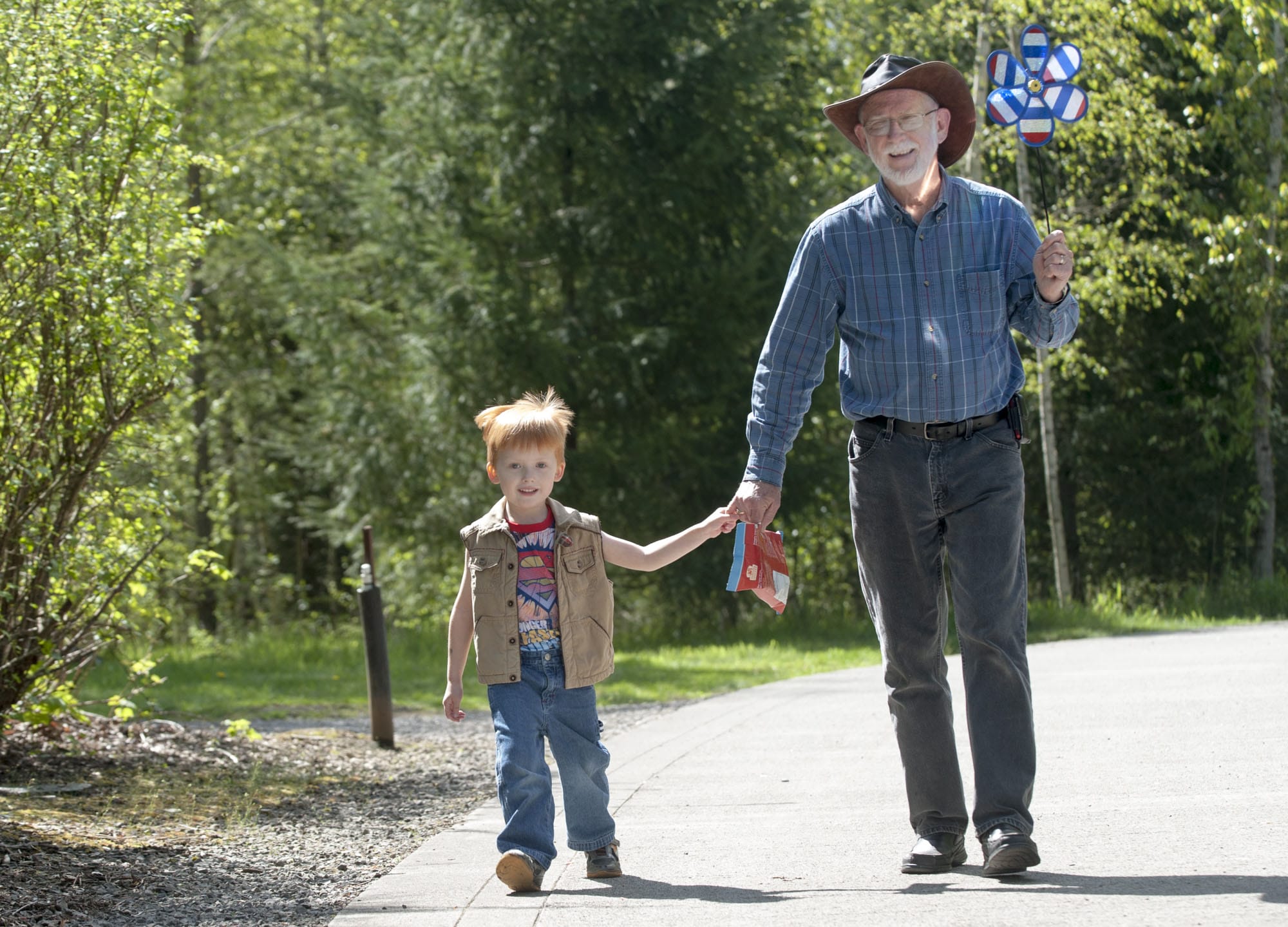 Samuel Eyk and his grandfather, Cal Eyk, stroll along Burnt Bridge Creek Trail in Vancouver on April 15. Samuel was very clear that the pinwheel belonged to him.