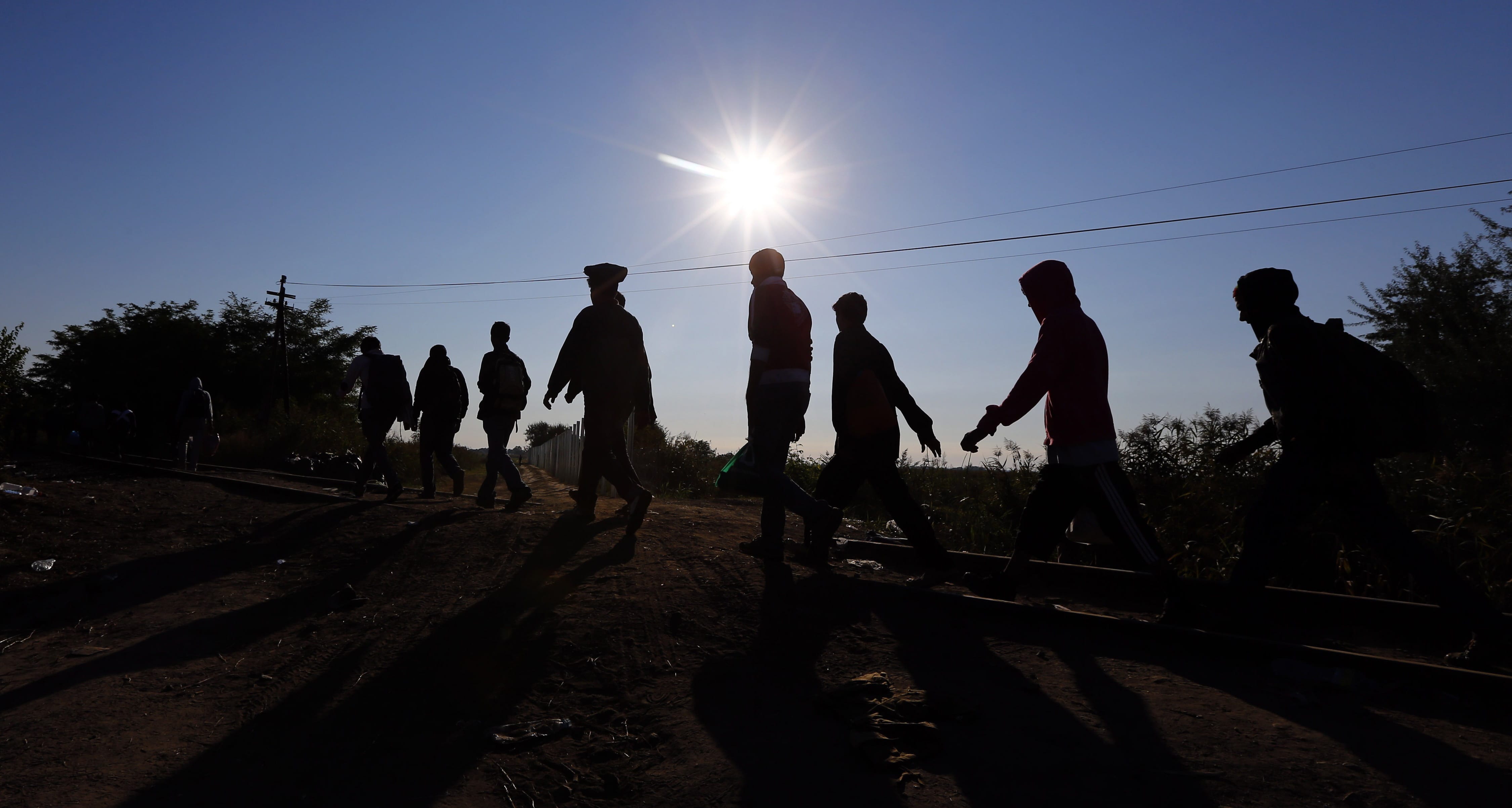 Migrants cross the Hungarian-Serbian border Sept. 9 near Roszke, southern Hungary. There are businesses for whom every migrant fleeing to Europe is a business opportunity.