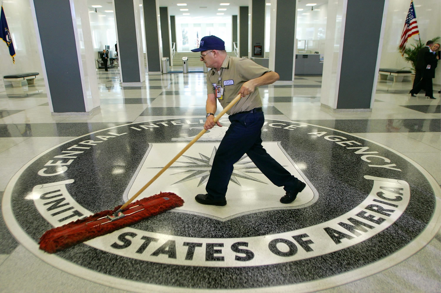 A workman slides a dustmop over the floor at the Central Intelligence Agency headquarters in Langley, Va., near Washington.