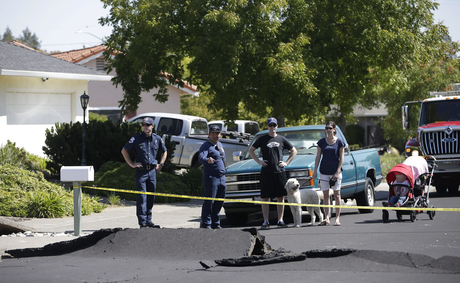 Yellow caution tape keeps traffic from passing  down Meadowbrook Drive, after a section the street buckled during an early morning earthquake Sunday, Aug. 24, 2014, in Napa, Calif.  The predawn earthquake ruptured water mains and gas lines and damaged some of the region's famed wineries.
