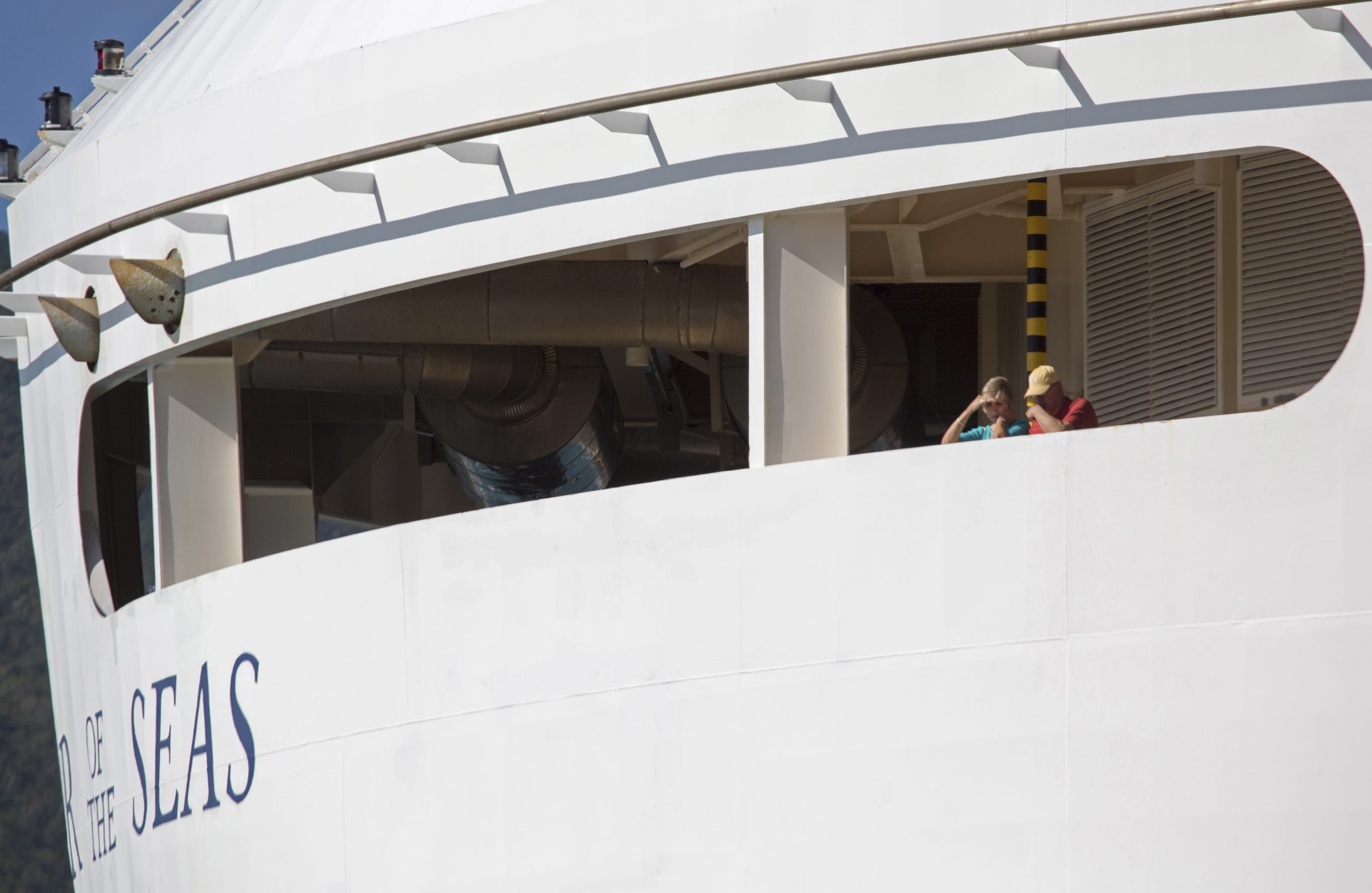 Passengers look out from the Royal Caribbean International's Explorer of the Seas, docked at Charlotte Amalie Harbor in St. Thomas, U. S.