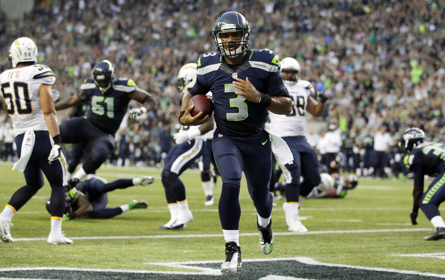Seattle Seahawks quarterback Russell Wilson runs for a touchdown in the first half of a preseason NFL game against the San Diego Chargers, Friday, Aug. 15, 2014, in Seattle. It was Wilson's second rushing touchdown in the first half.