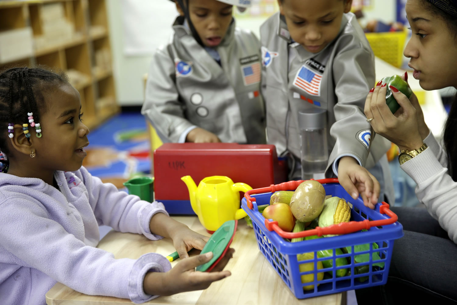 Oumou Balde, 4, left, plays with her teacher Jacqualine Sanchez, right, and pretend food in a pre-kindergarten class at the Sheltering Arms Learning Center in New York in a program to educate children about nutrition and health.