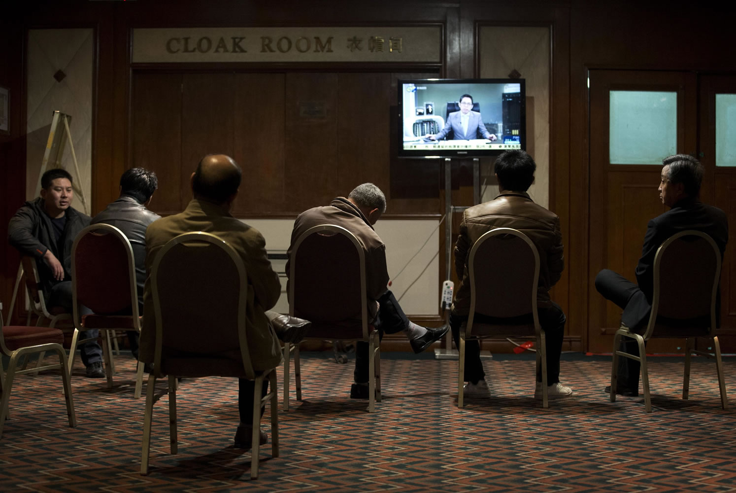 Relatives of Chinese passengers aboard the missing Malaysia Airlines flight watch a TV news program about the plane at a hotel ballroom in Beijing on Thursday.