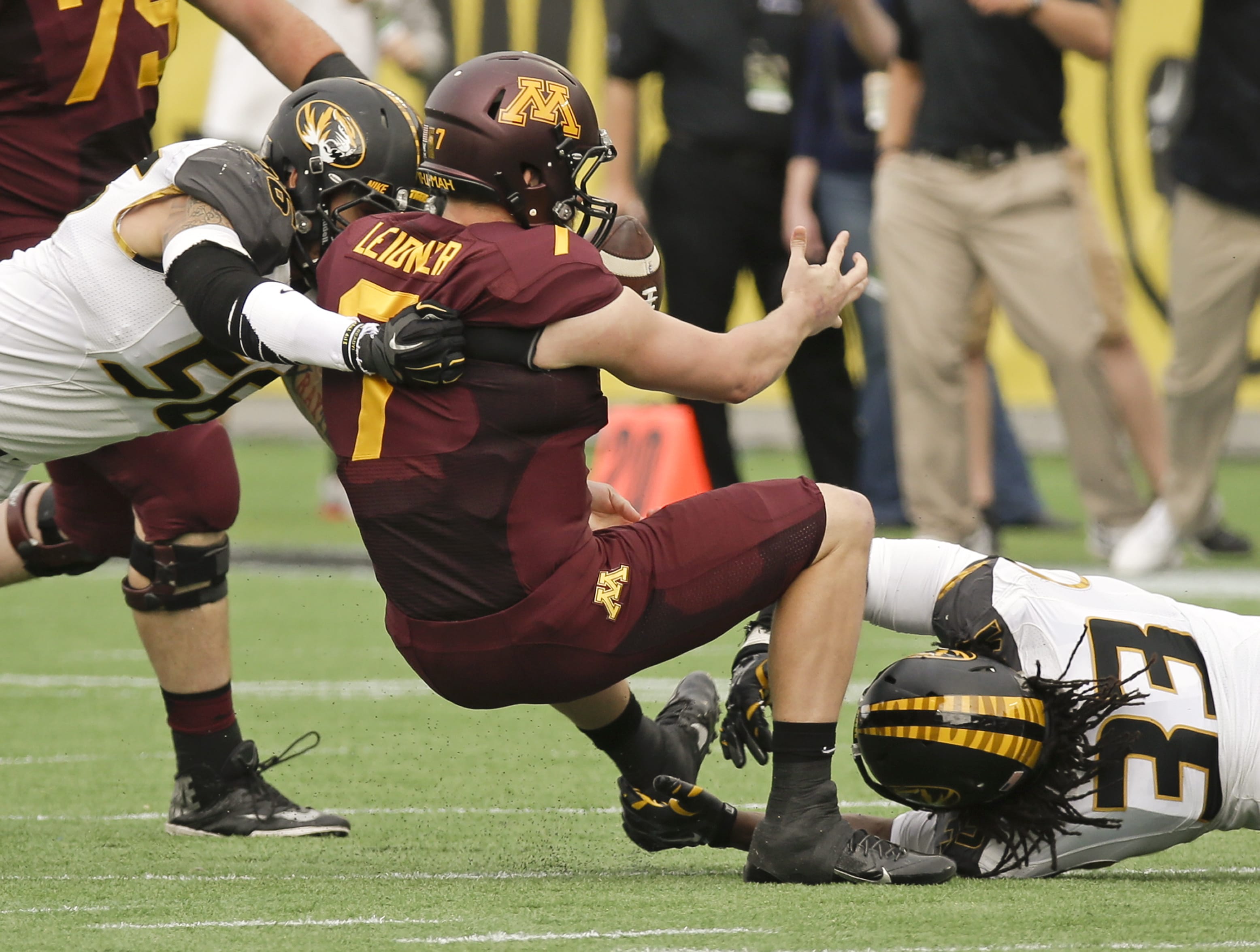 Minnesota quarterback Mitch Leidner (7) fumbles the ball as he is tackled by Missouri's Shane Ray, left, and Markus Golden (33) during the first half Thursday of the Citrus Bowl.