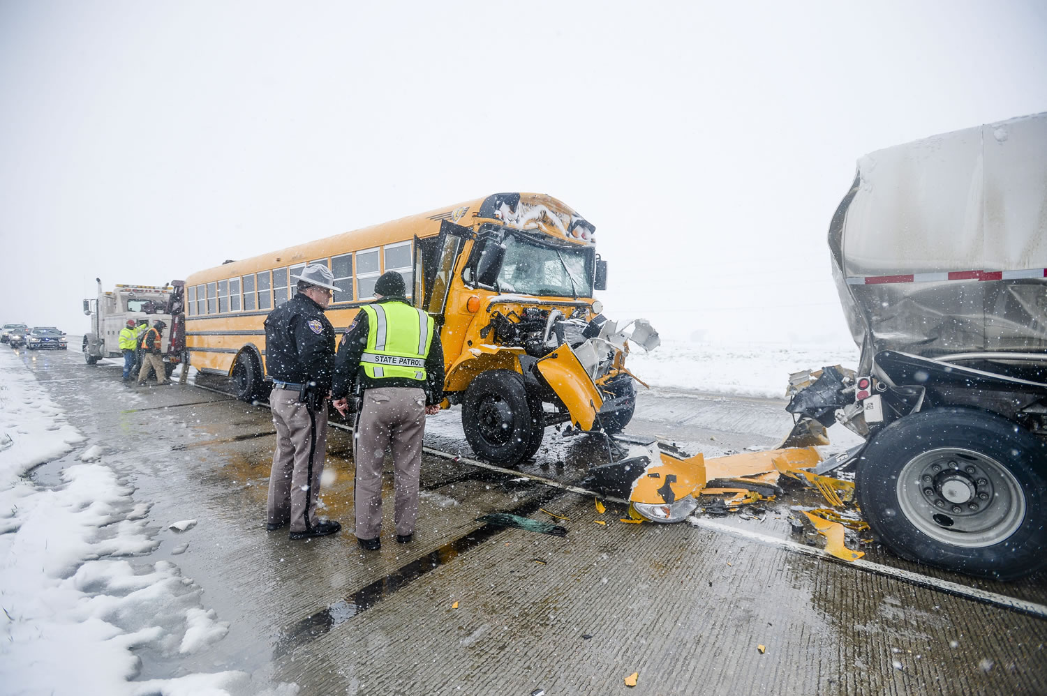 Crews clean up a school bus and semitrailer collision on northbound I-25 on Sunday in Fort Collins, Colo.