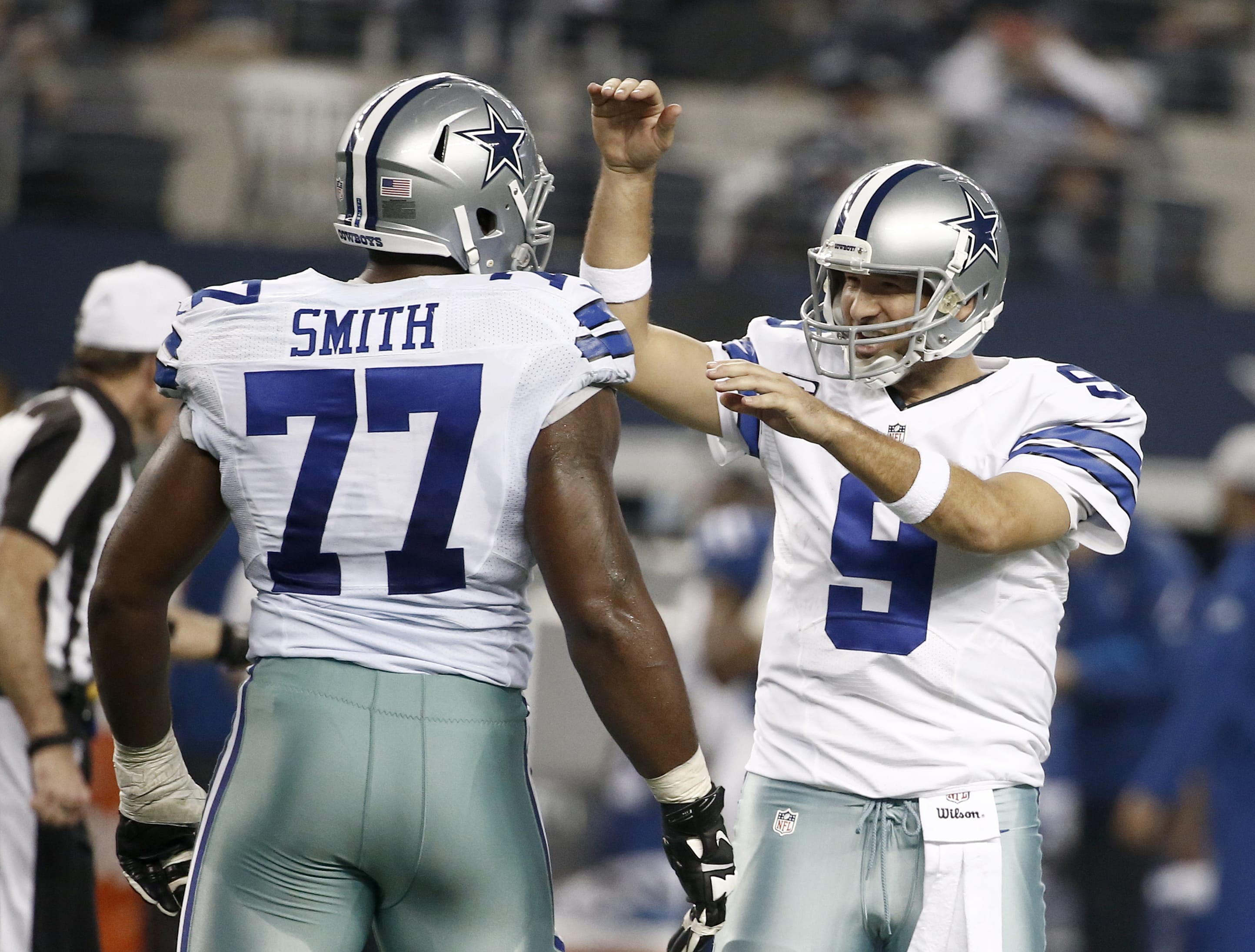 Dallas Cowboys quarterback Tony Romo (9) celebrates with Tyron Smith (77) after throwing a touchdown pass to Jason Witten during the second half against the Indianapolis Colts, Sunday, Dec. 21, 2014, in Arlington, Texas.
