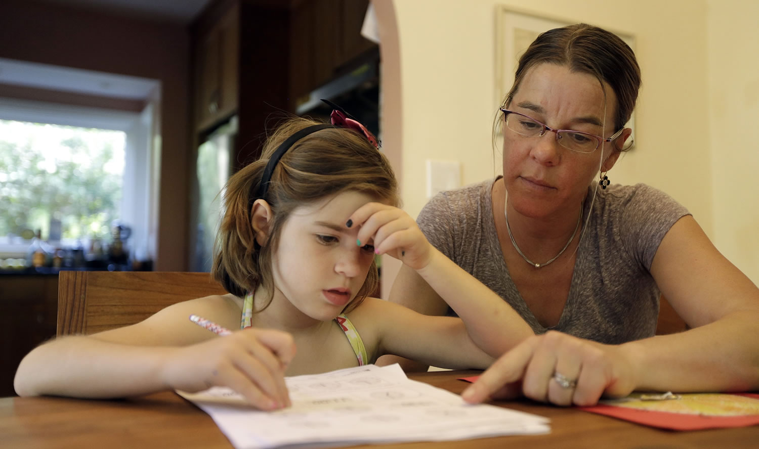 Associated Press
Stacey Jacobson-Francis, right, works on math homework with her daughter Luci, 6, at their home in Berkeley, Calif. Parents trying to help their kids with math homework say the basics have become as complicated as calculus.