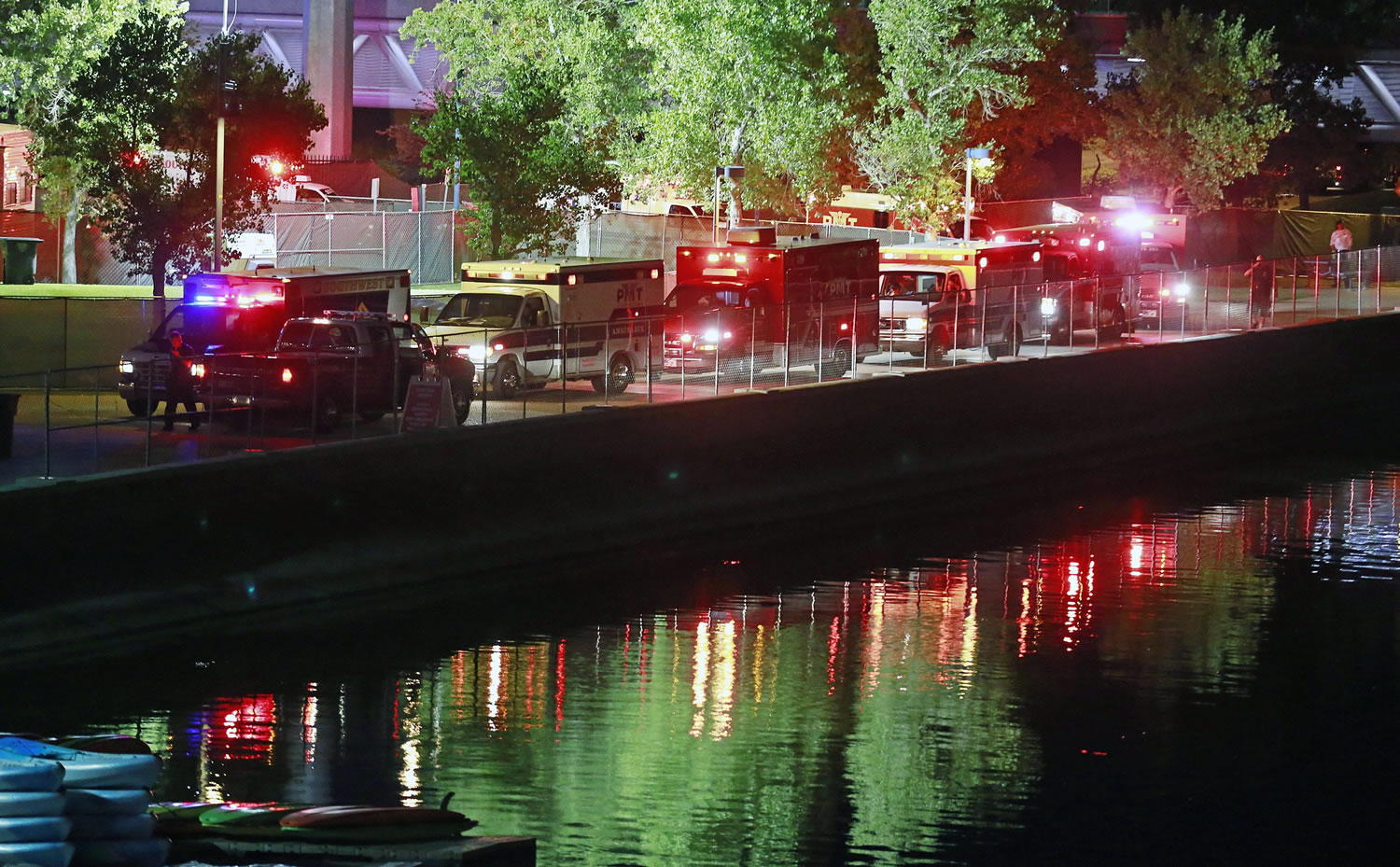 Fire units and ambulances line up to transport injured concertgoers Saturday at Tempe Beach Park in Tempe, Ariz. An Arizona music festival was scheduled to resume Sunday for a Kanye West performance after as many as 12 people were injured when a crowd rushed a stage Saturday night.
