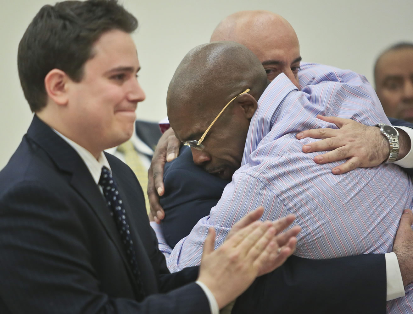 Jonathan Fleming hugs attorney Anthony Mayol while his other attorney, Taylor Koss, applauds in court in Brooklyn after a judge declared him a free man Tuesday.