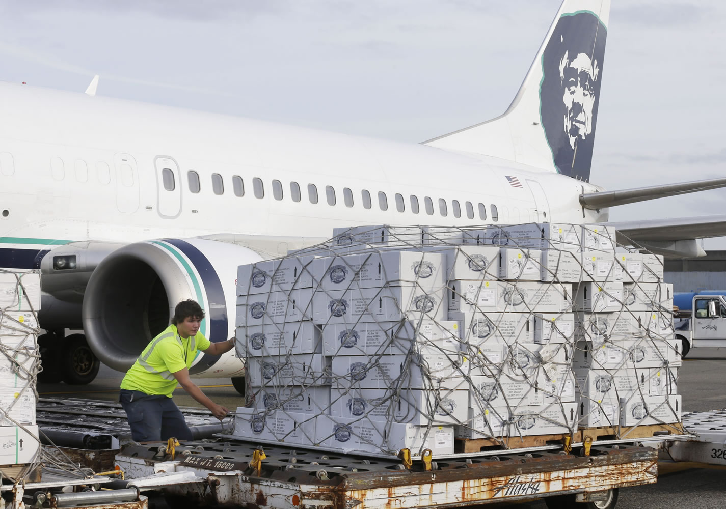 Gary Johnson, left, an Alaska Airlines cargo worker, positions a pallet of the first shipment of Copper River salmon Friday in SeaTac.