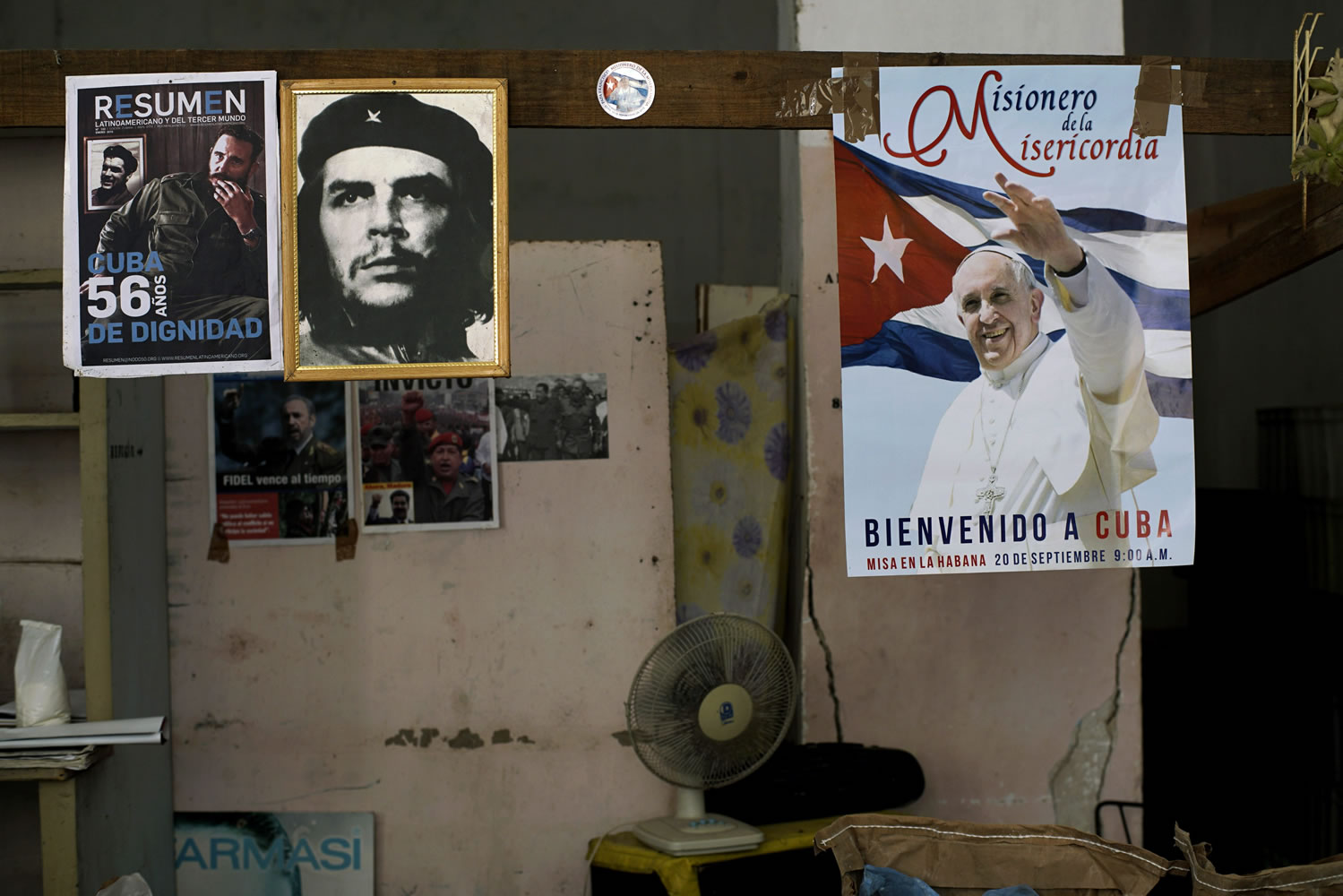 A poster of Pope Francis hangs next to a picture of revolutionary hero Ernesto "Che" Guevara and Fidel Castro inside a state store that sells flour and beans in Havana, Cuba, on Friday. Francis delivered an unprecedented televised message to the Cuban people on Thursday night ahead of a four-day trip to the island.