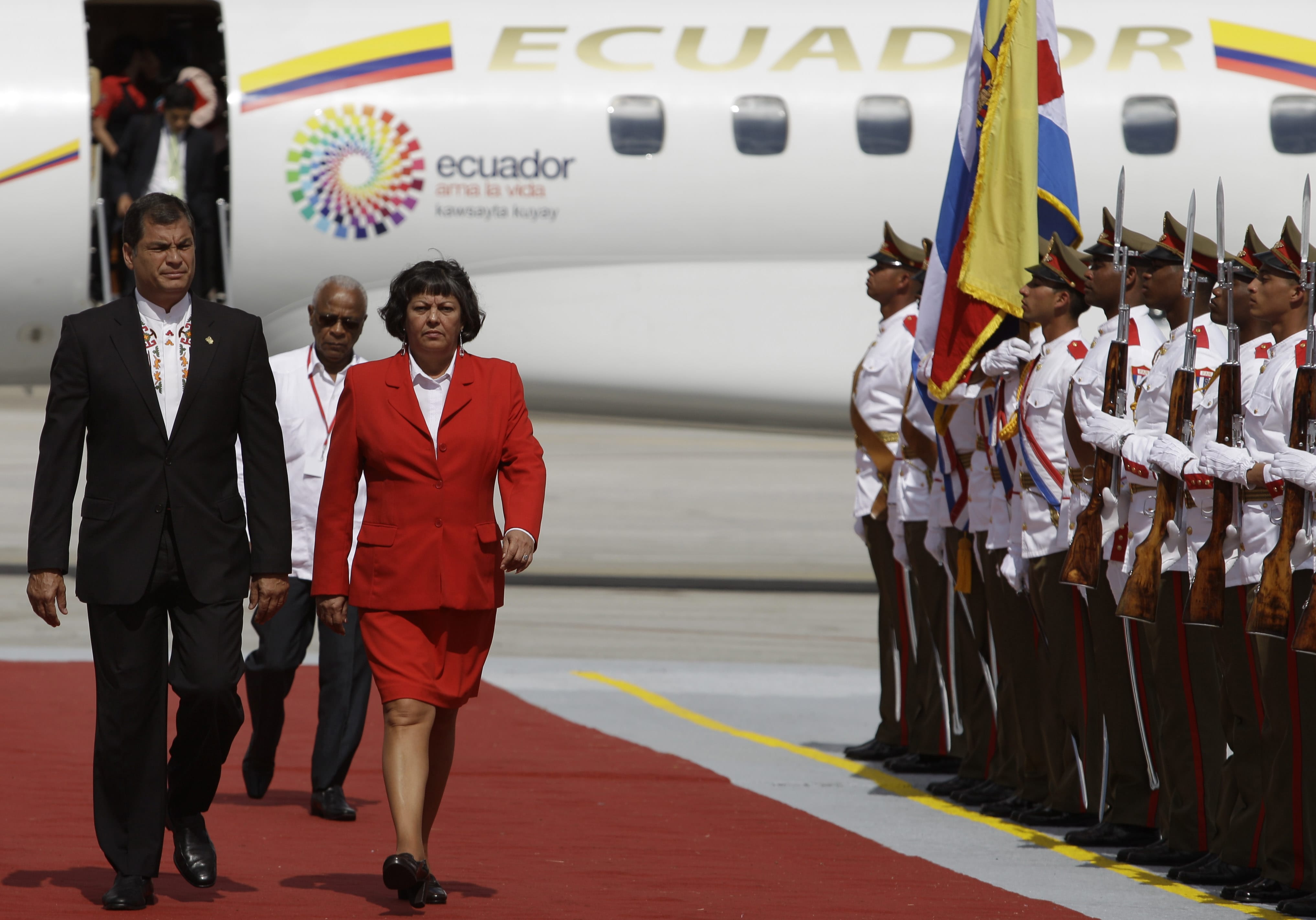Ecuador's President Rafael Correa, left, walks with Cuba's Minister of Labor and Social Security Margarita Marilene Gonz?lez at the Jose Marti International airport in Havana, Cuba, on Tuesday.