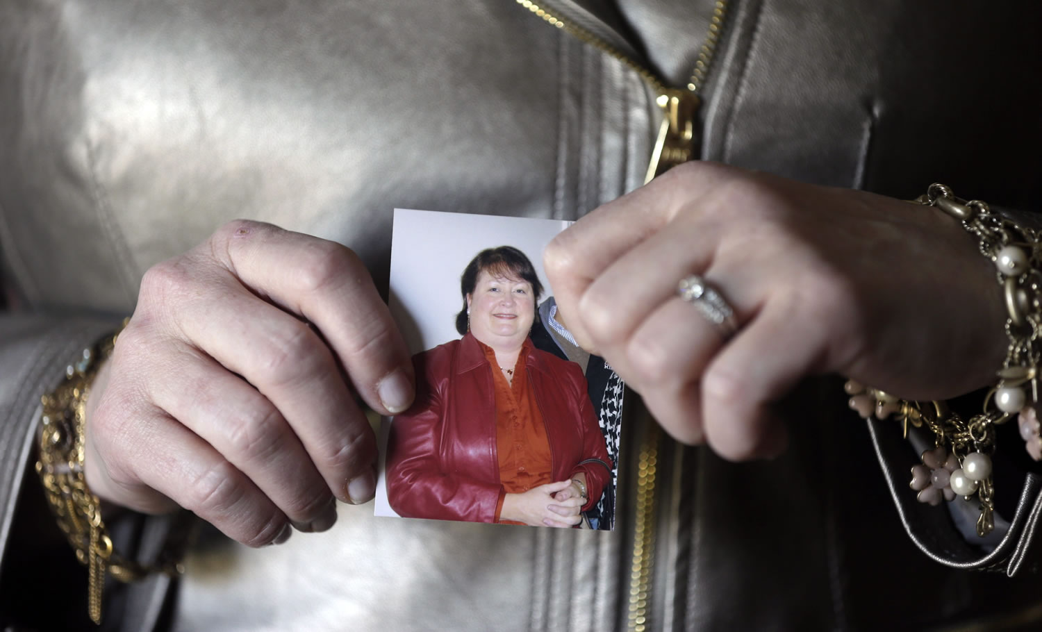 Heather Britton holds a photo of herself made before her weight-loss surgery at her home in Bay Village, Ohio.