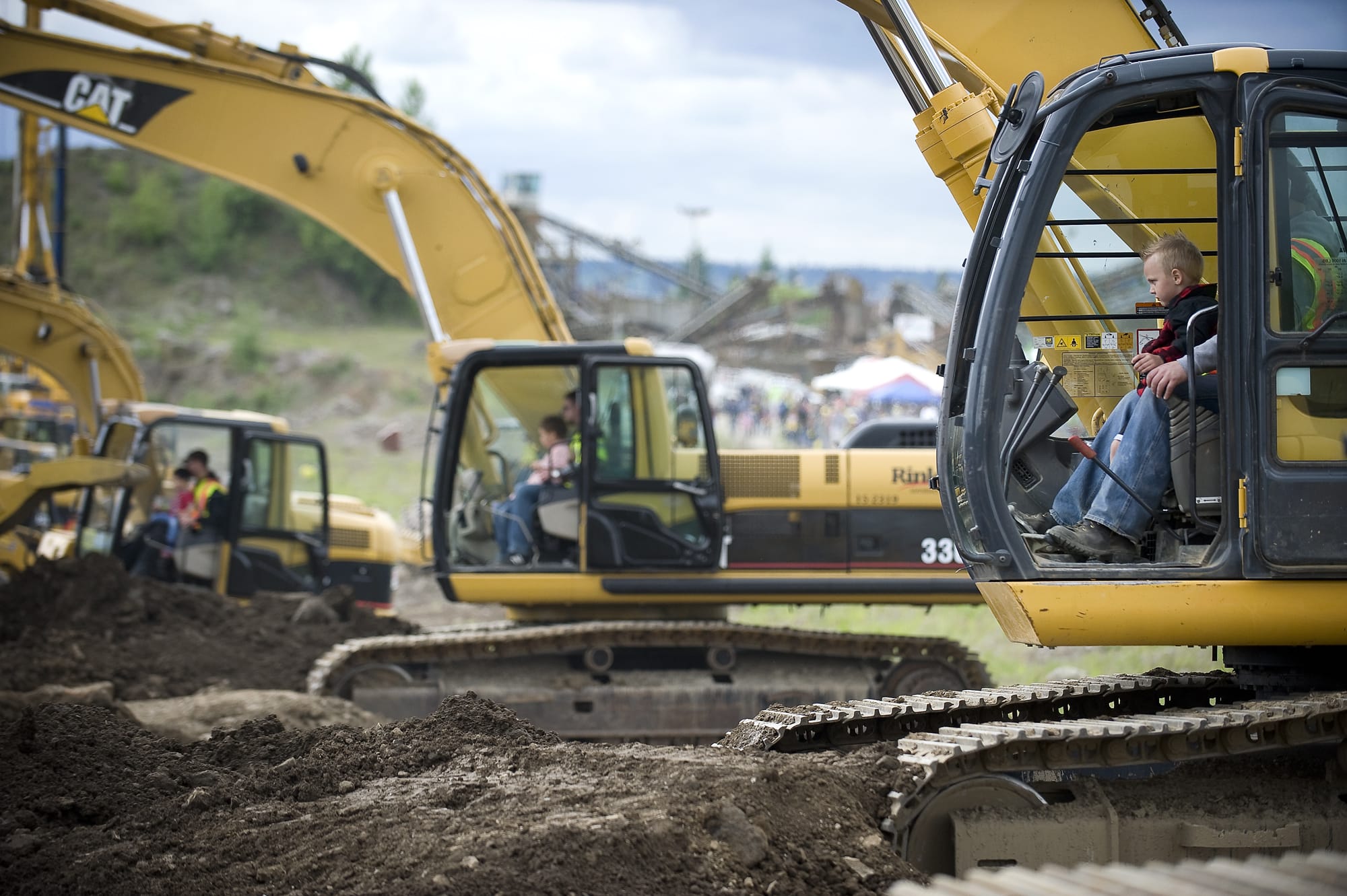 Ryder Loftis operates an excavator with help from operator Curt Spragg at Dozer Day in 2011.