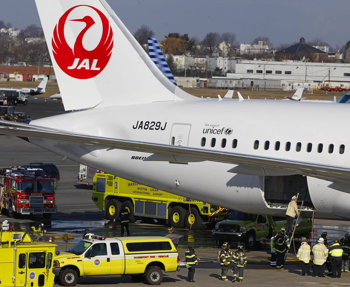 A Japan Airlines Boeing 787 jet aircraft is surrounded by emergency vehicles while parked at a terminal at Logan International Airport in Boston on Jan.