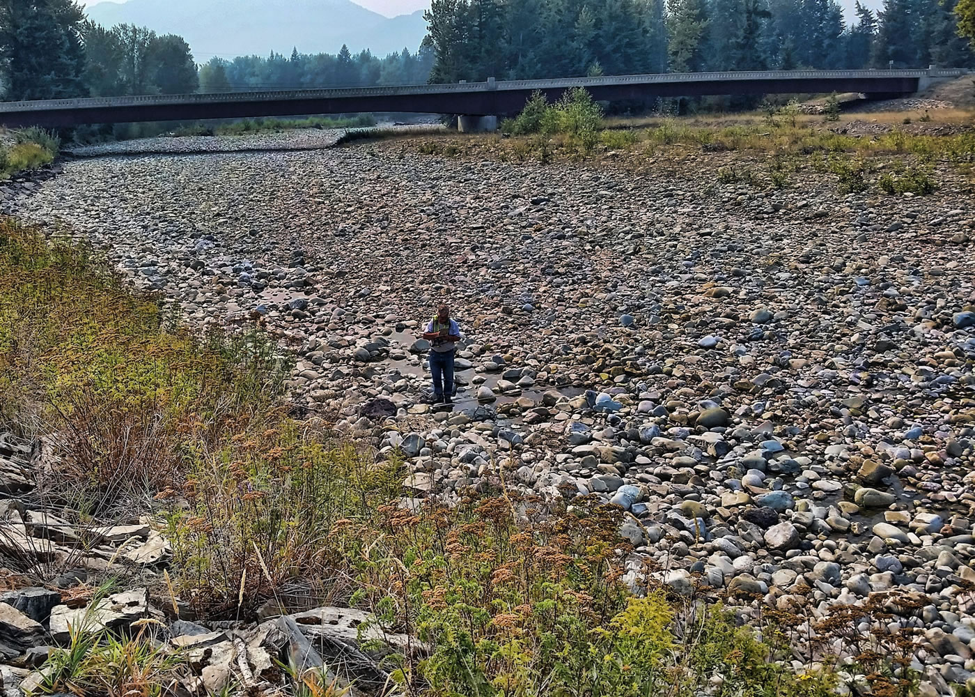 In this Aug 27, 2015 photo, a hydrologic technician from the U.S. Geological Survey Idaho Water Science Center measures streamflow in Lightning Creek at Clark Fork, Idaho. Federal scientists are conducting a drought study in six western states in an attempt to gain insights that could help resource managers better allocate scarce water supplies during future droughts. (Ryan Smith/U.S.