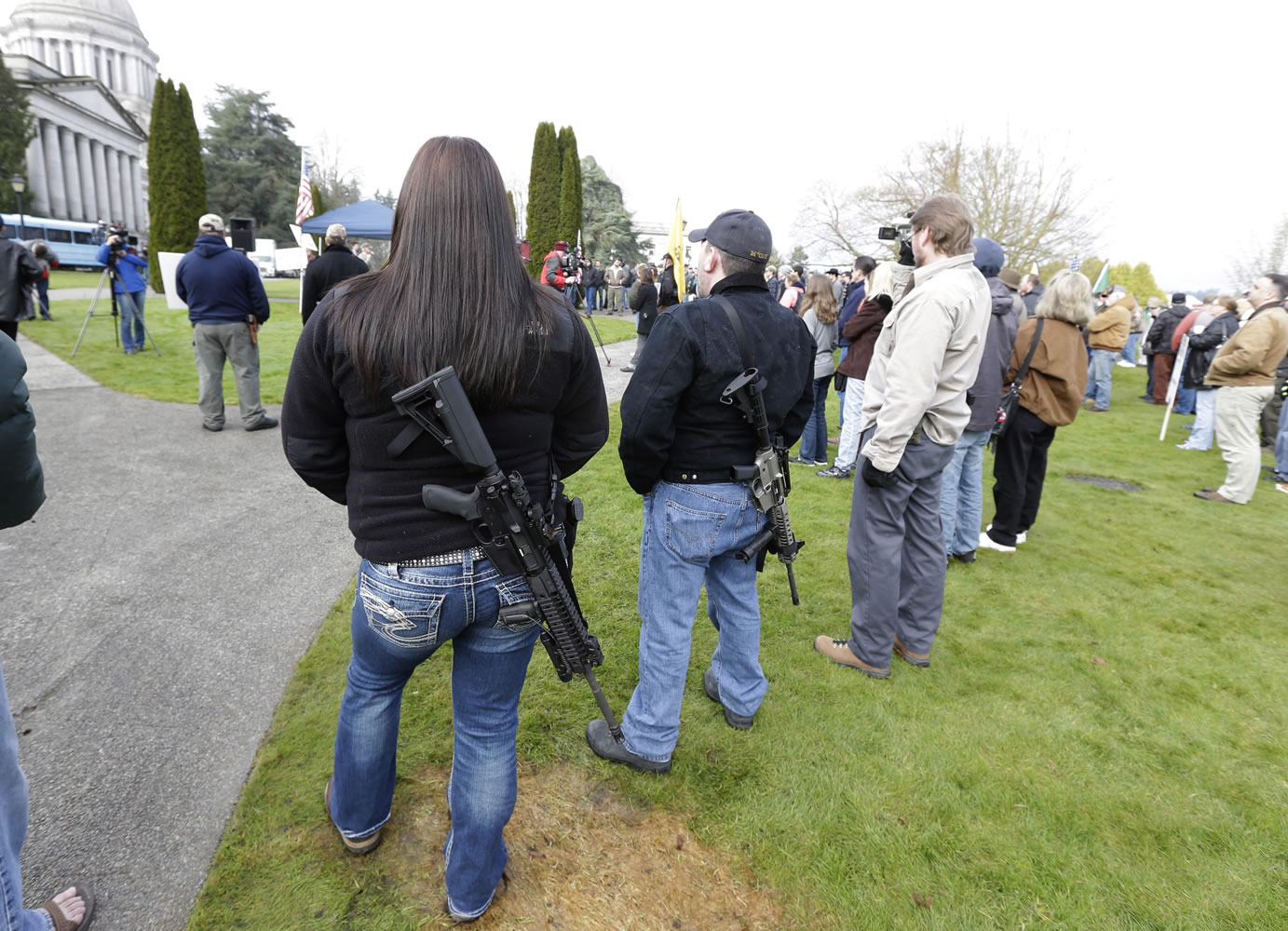 Laura Huff, left, of Lacey, and Mike McCoy, second from right, wear M4 rifles during a gun rights rally Feb. 8, 2013, at the Capitol in Olympia.