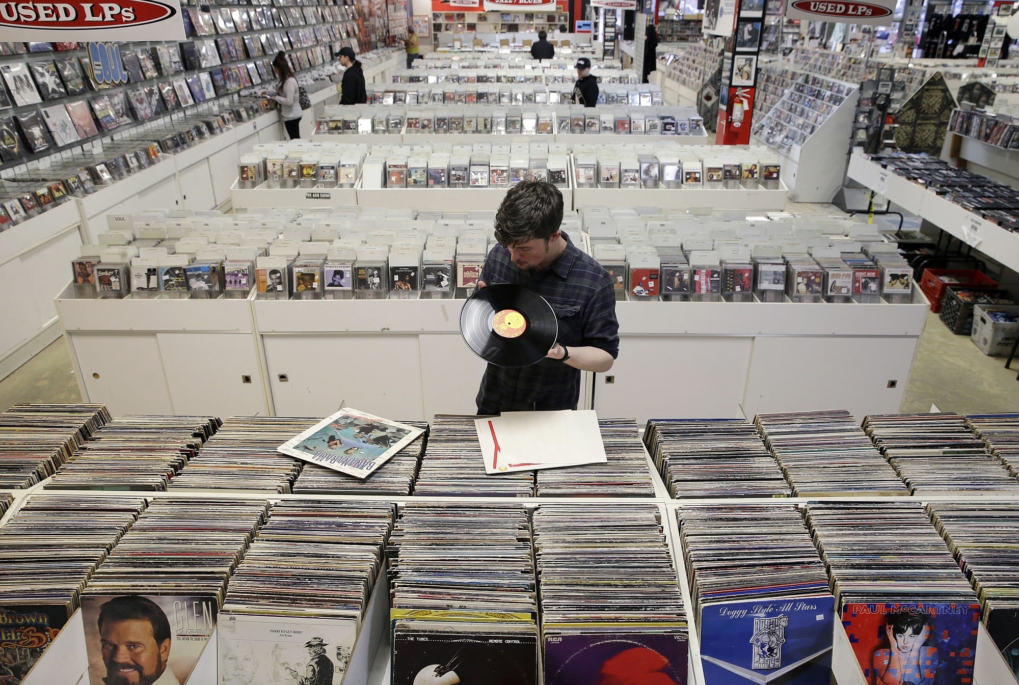 Record clerk Josh Kelly checks the condition of used albums Tuesday as he puts them in sales bins at Vintage Vinyl Records in Fords, N.J.