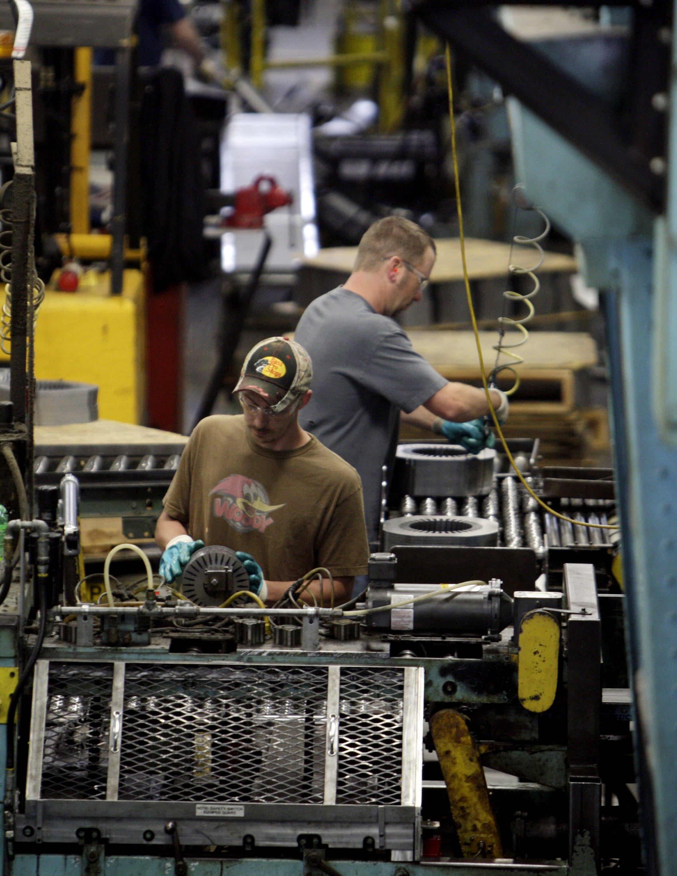 Baldor Electric Co. employees Dave Johnston, left, and Steve Davis, right, work inside the company's factory in St.