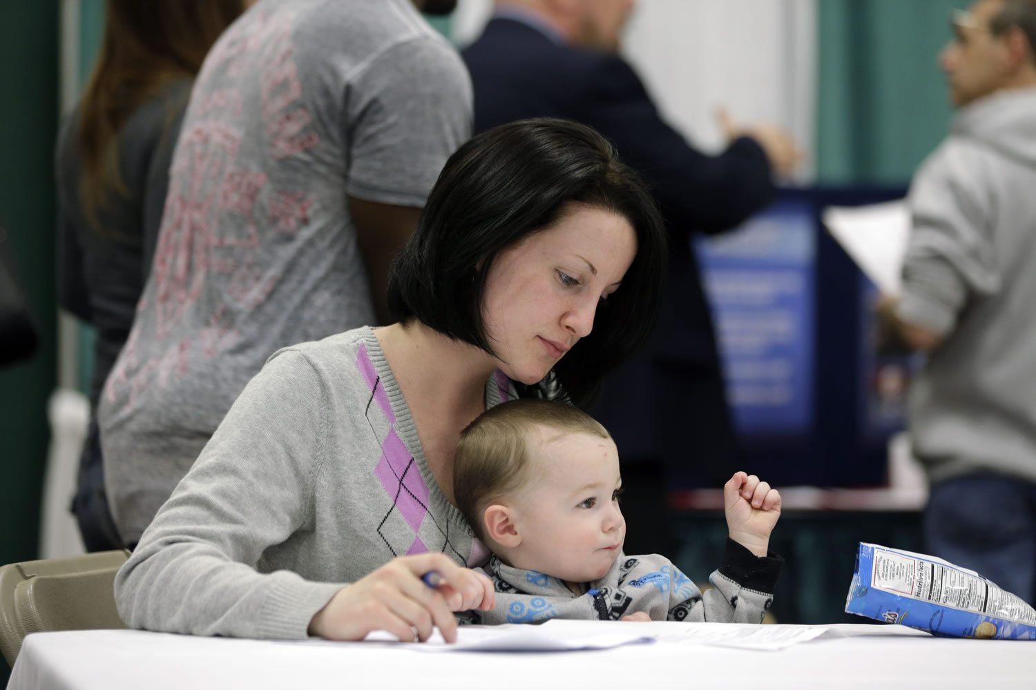 Sarah Keegan of Windham, N.Y., with her son Kevin, fills out paperwork April 22 during a job fair at Columbia-Greene Community College in Hudson, N.Y. The Labor Department on Friday said U.S.