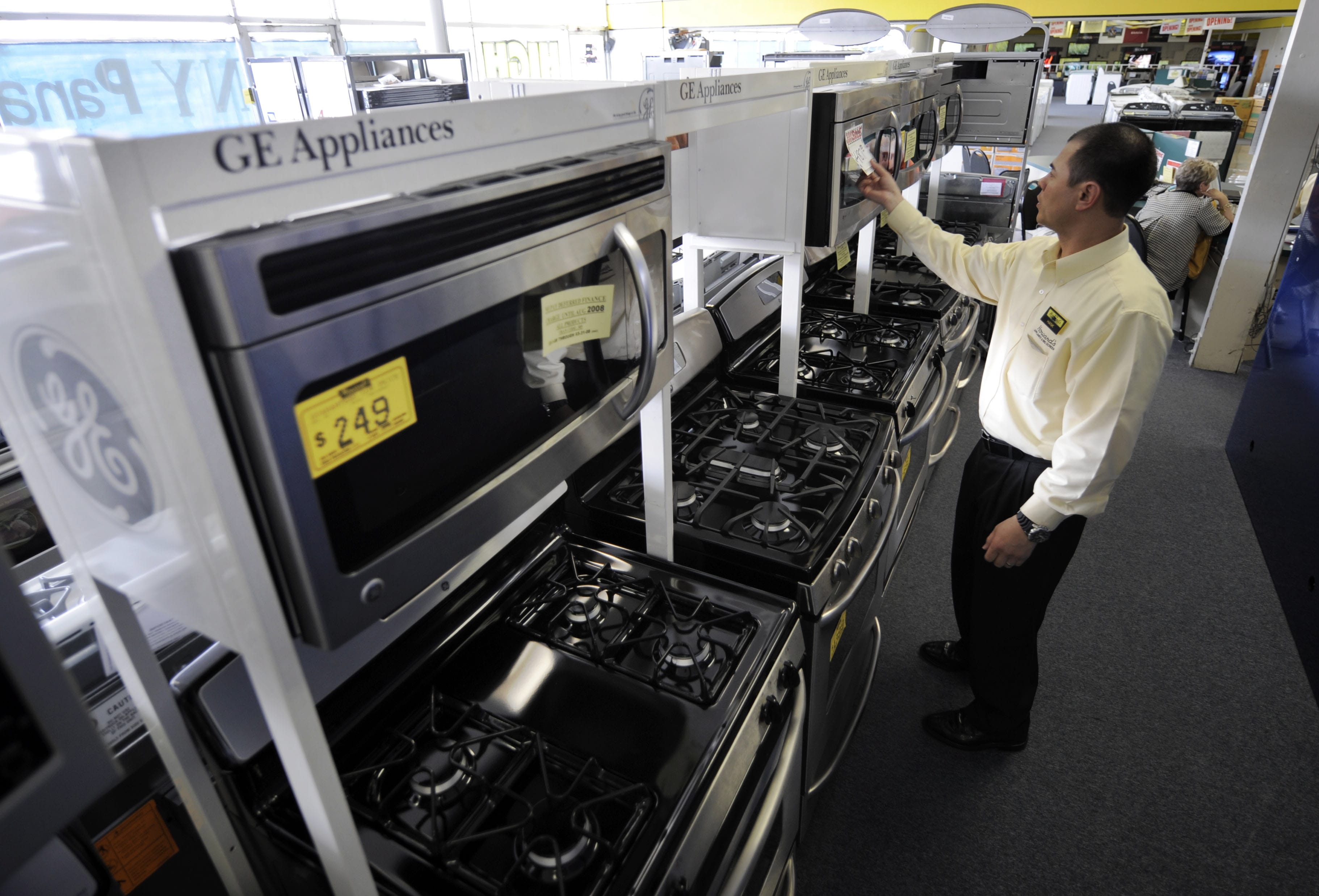Salesman Hank Pham puts the price on a General Electric microwave in the appliances section of Howard's Appliance and Big-Screen Superstore in San Gabriel, Calif.