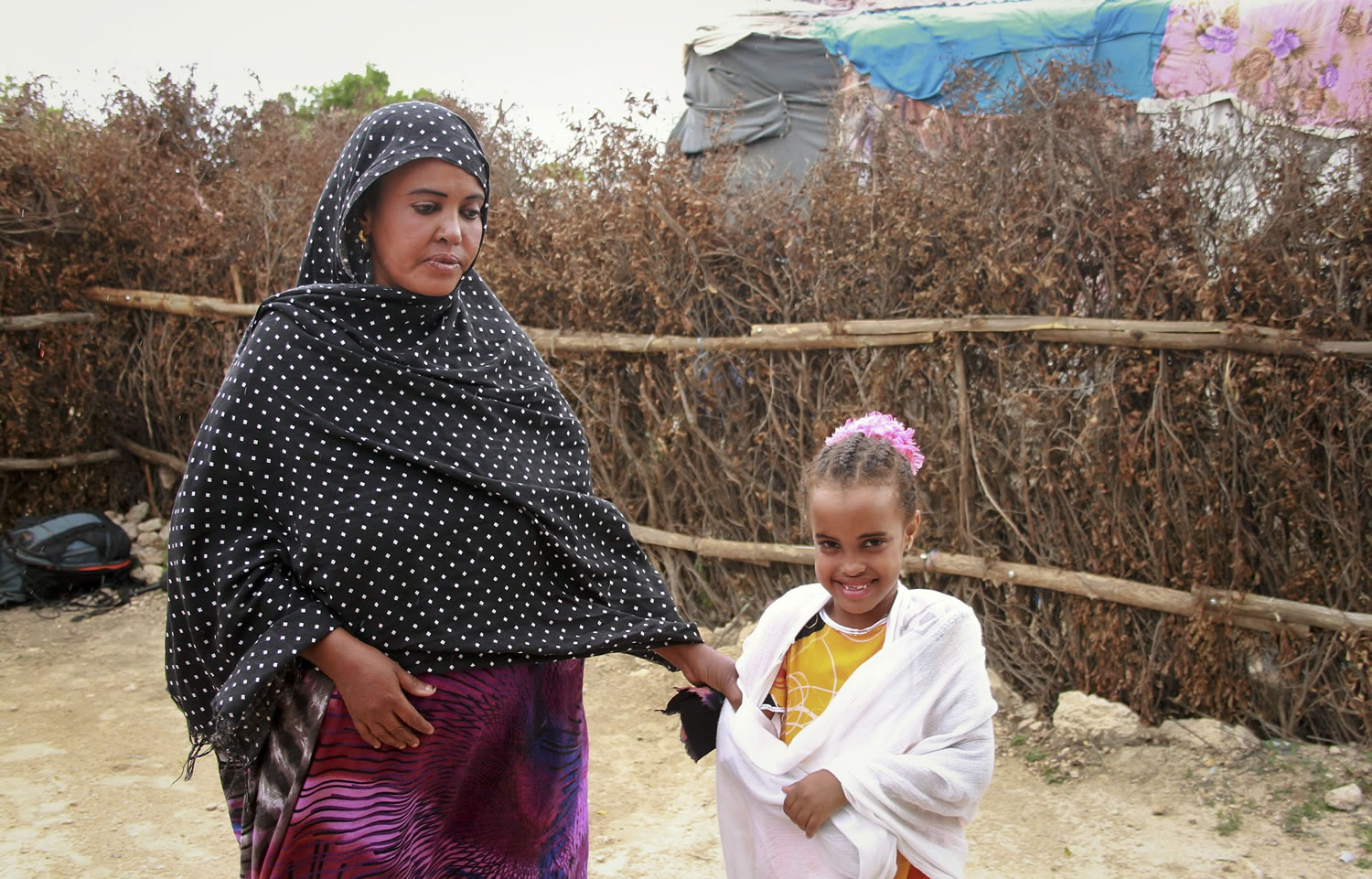 Ubah Mohammed Abdule, 33, left, walks with her daughter, Neshad Yusuf Ahmed, 5, right, outside her hut in the Shedder refugee camp near the town of Jigjiga, in far eastern Ethiopia.