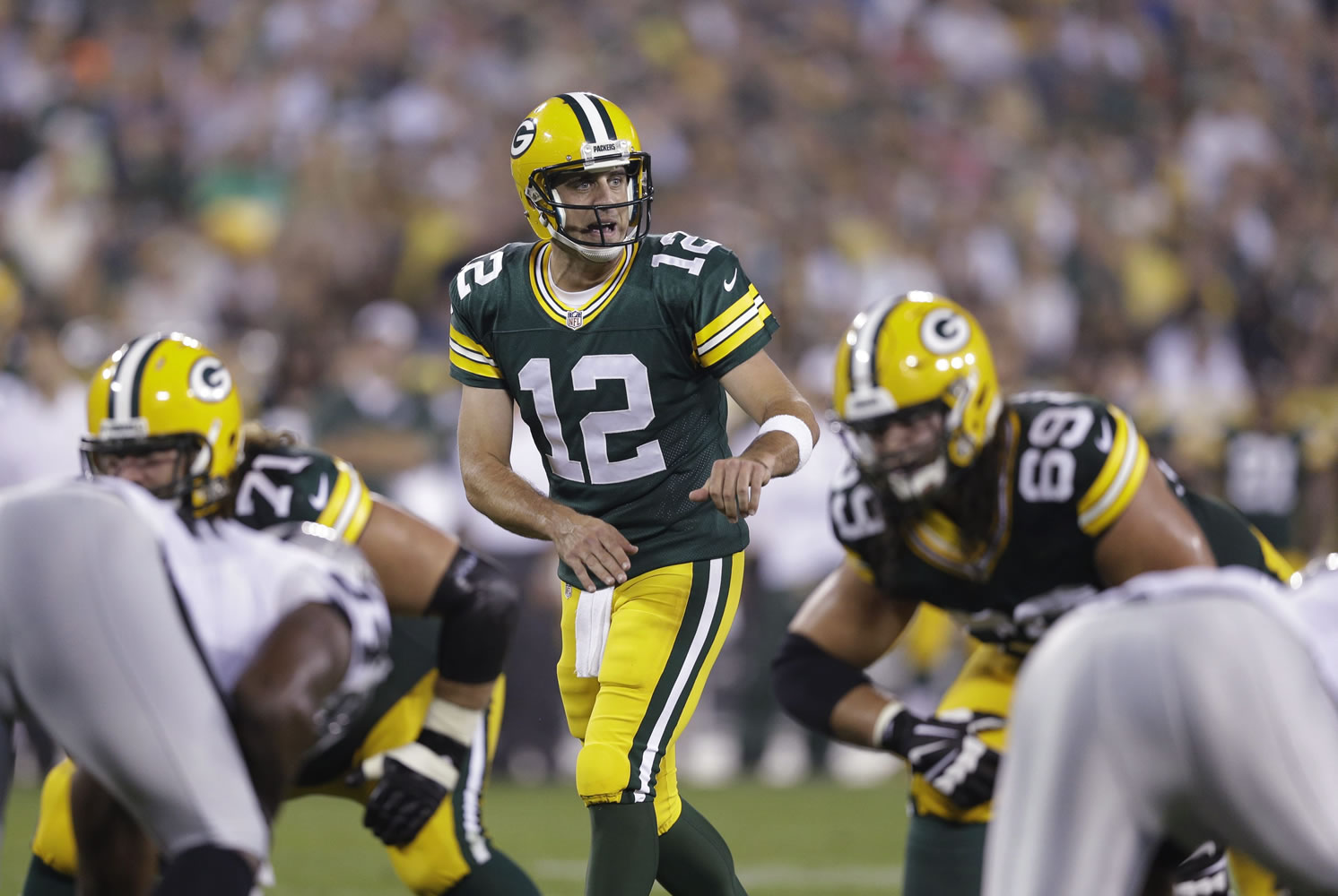 Green Bay Packers quarterback Aaron Rodgers approaches the line of scrimmage during a preseason football game against the Oakland Raiders in Green Bay, Wis.