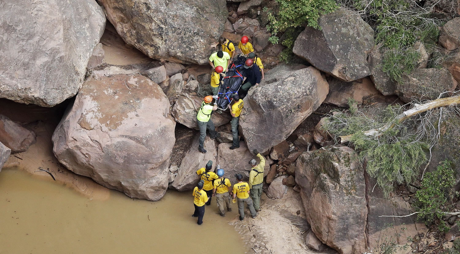 Search and rescue team members carry a body after it was found along Pine Creek, Wednesday, Sept. 16, 2015, in Zion National Park, near Springdale, Utah. Authorities are searching for other hikers killed in flash flooding that swept through a narrow canyon at Utah's Zion National Park.