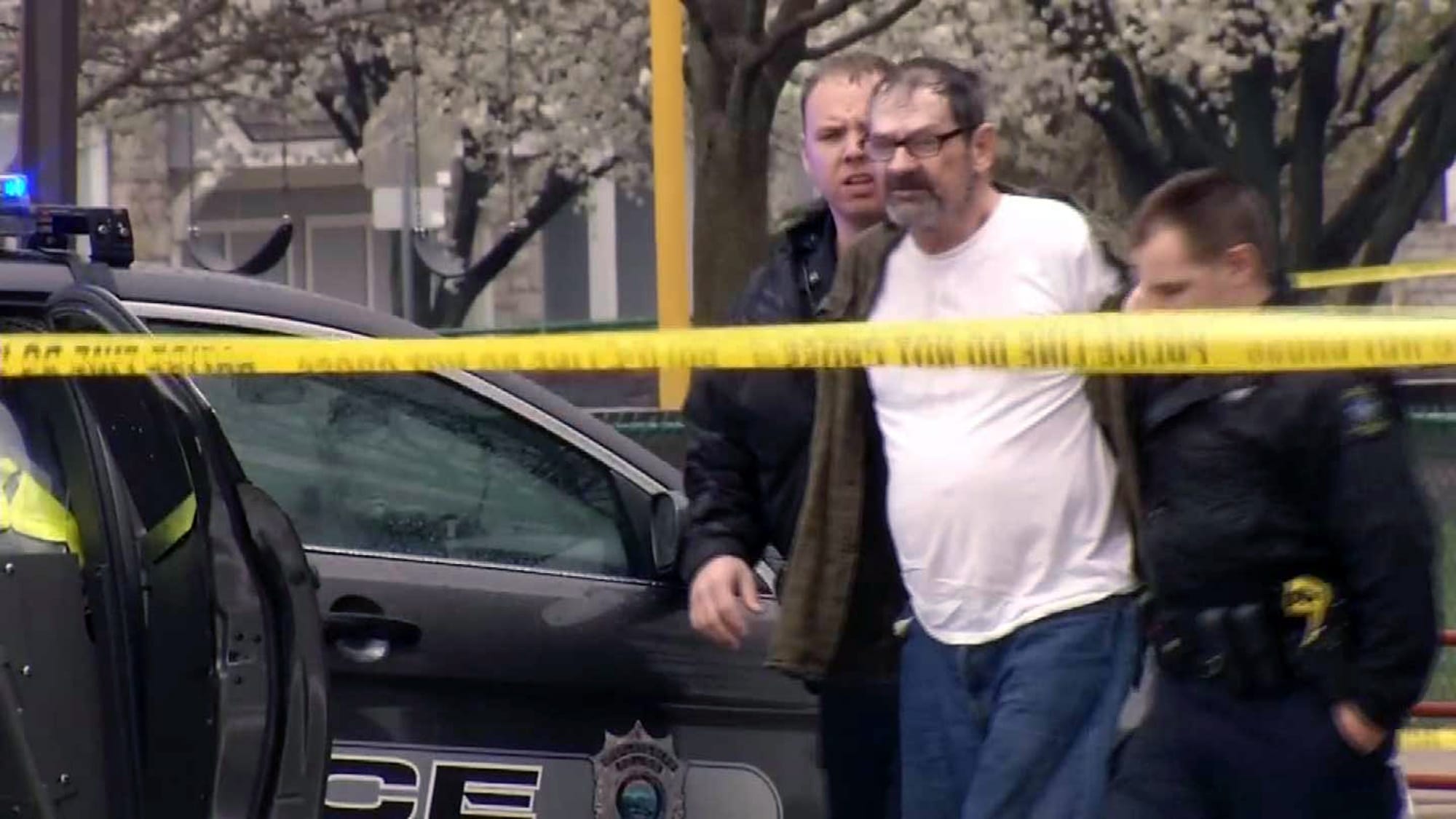 In this Sunday image from video provided by KCTV-5, Frazier Glenn Cross, also known as Frazier Glenn Miller, is escorted by police in an elementary school parking lot in Overland Park, Kan.