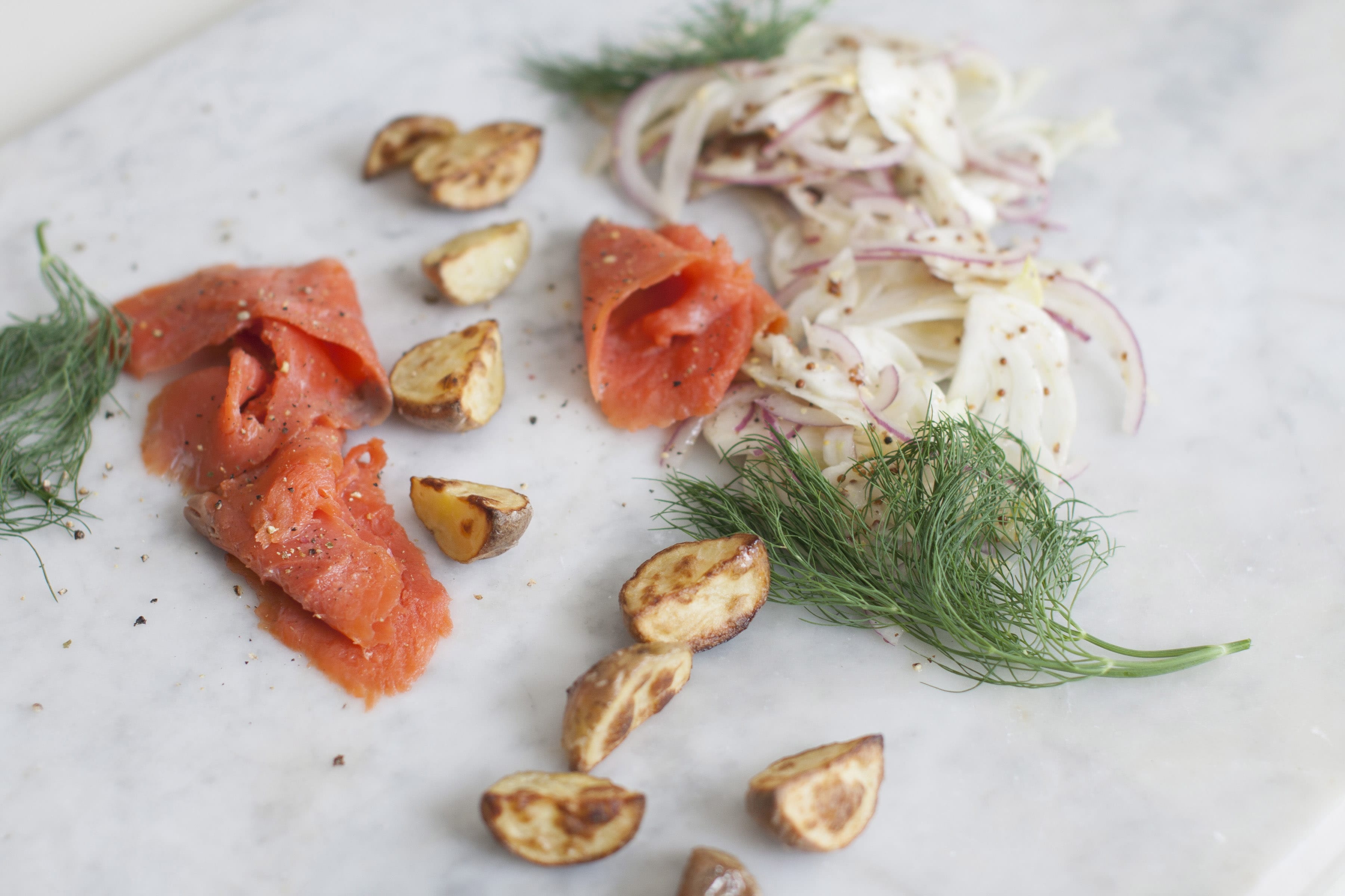 The ingredients for this salad are so simple: shaved fennel and red onion, a light dressing, thinly sliced smoked salmon, new potatoes, oil and black pepper.