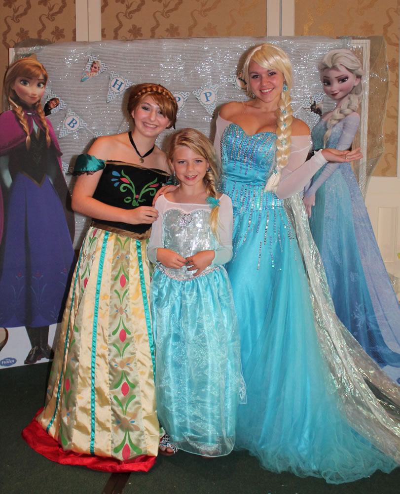 Kristin Calder/Associated Press
Caroline Calder poses at her ninth birthday party May 31 with Devin Tupler and Hannah Solimini, performers portraying princesses Elsa and Anna from the movie &quot;Frozen.&quot;