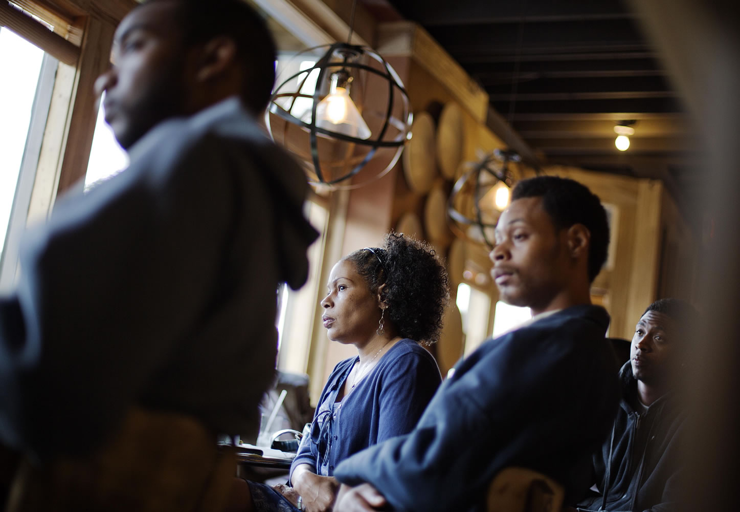 Lisa Marie Hyman-Walker, center, and son Eugene Mosby, right, listen to Leo Smith, minority engagement director for the Georgia Republican Party, speaking at the Delightful Eatz Bar and Grill in the historically African American neighborhood of Edgewood in Atlanta.