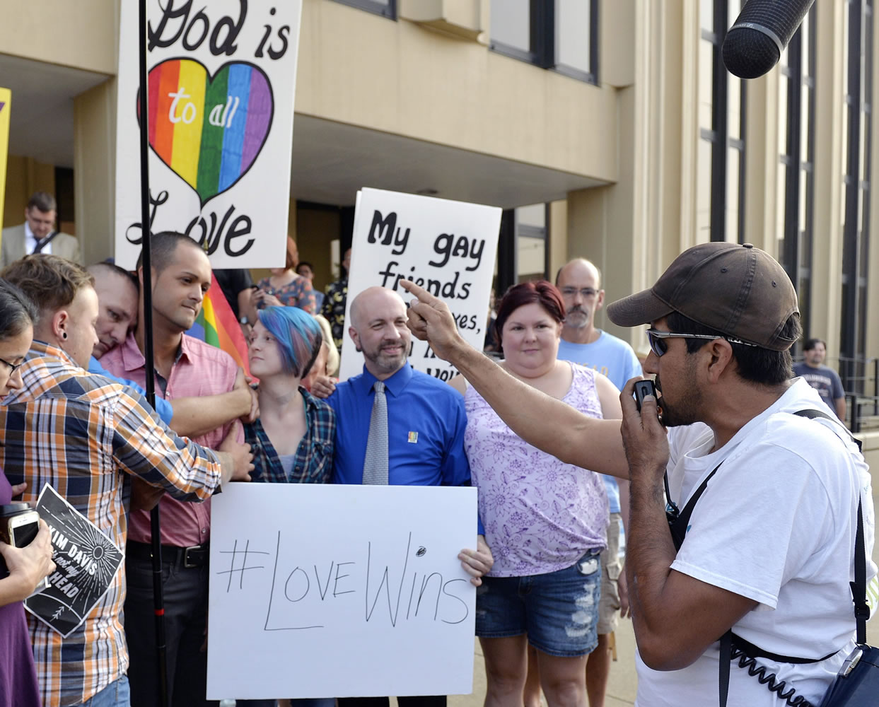 Edgar Orea, right, preaches to a group of same sex marriage supporters that have gathered Thursday outside the Carl D. Perkins Federal Building in Ashland, Ky.