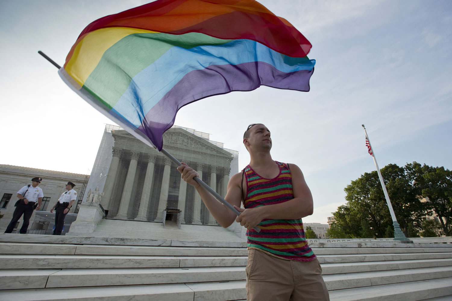 Gay rights advocate Vin Testa waves a rainbow flag June 26, 2013 in front of the Supreme Court in Washington. Both sides in the gay marriage debate agree on one thing: It's time for the Supreme Court to settle the matter.
