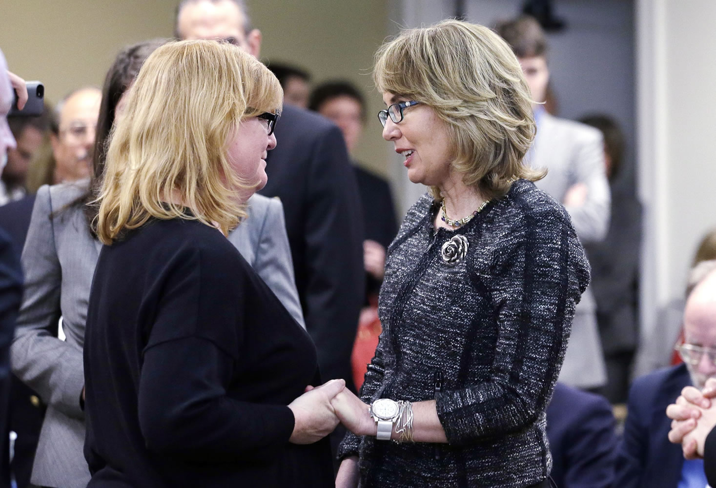 Former Arizona Congresswoman Gabrielle Giffords, right, greets Cheryl Stumbo, who, like Giffords, survived being shot, after both testified before a Washington state House panel Tuesday in Olympia.