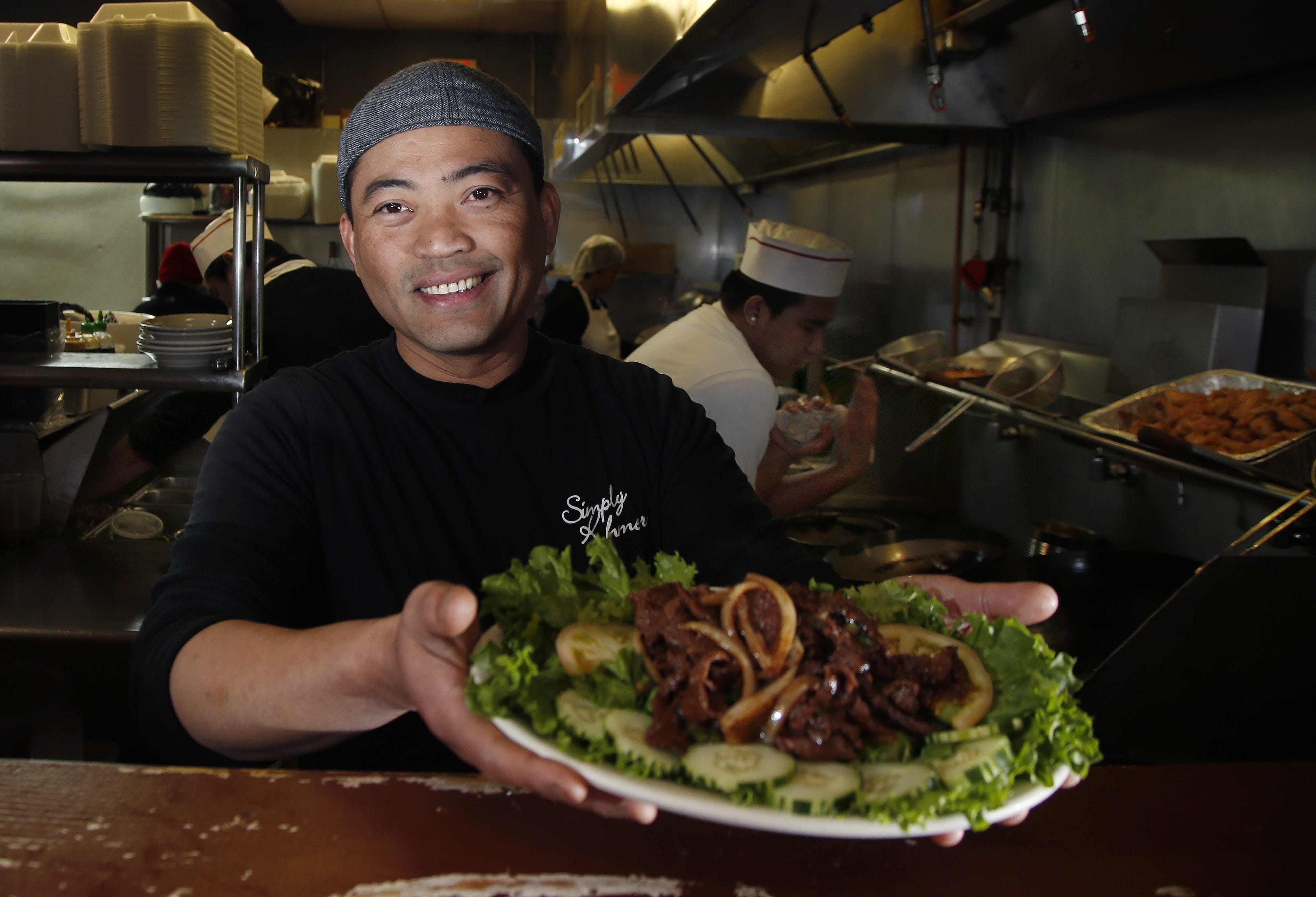 Chef Sambath Neang of Cambodian restaurant Simply Khmer presents a beef loc lac plate during lunchtime in Lowell, Mass.