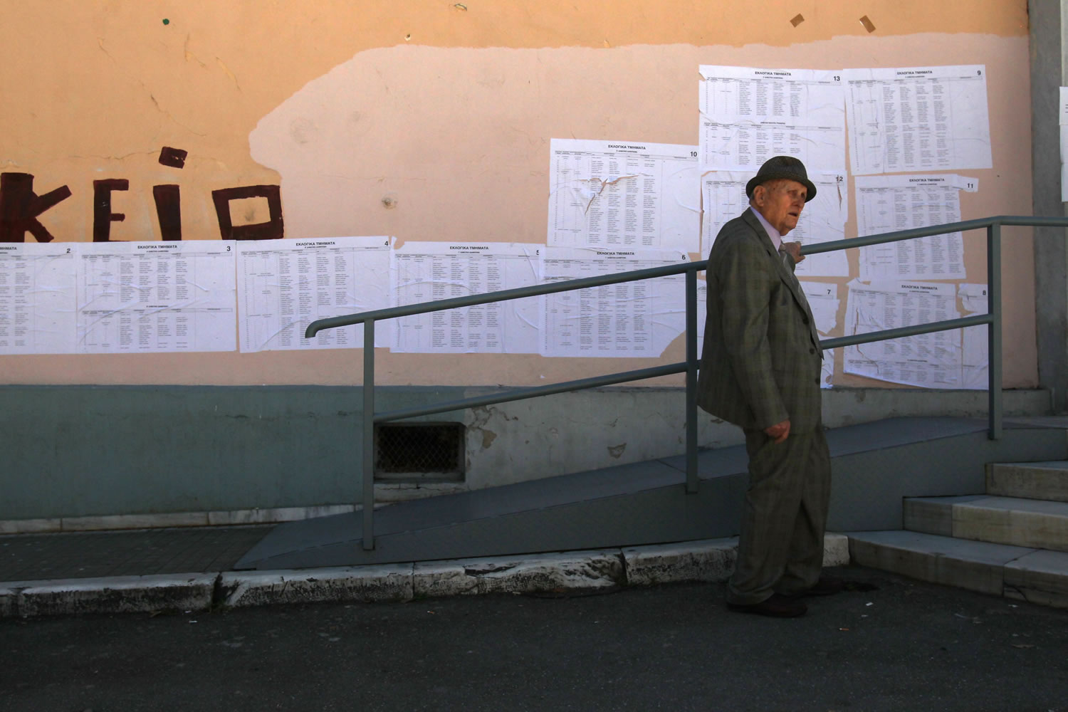 An elderly man stands outside of a polling station, in northern Greek city of Thessaloniki, on Sunday.