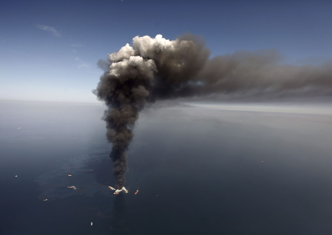 FILE -  In this Wednesday, April 21, 2010 file photo, oil can be seen in the Gulf of Mexico, more than 50 miles southeast of Venice on Louisiana's tip, as a large plume of smoke rises from fires on BP's Deepwater Horizon offshore oil rig. An April 20, 2010 explosion at the offshore platform killed 11 men, and the subsequent leak released an estimated 172 million gallons of petroleum into the gulf. U.S. District Judge Carl Barbier ruled Thursday, Sept. 4, 2014, in New Orleans, La., that BP acted recklessly and bears most of the responsibility for the oil spill. The ruling exposes BP to about $18 million in civil fines under the Clean Water Act.