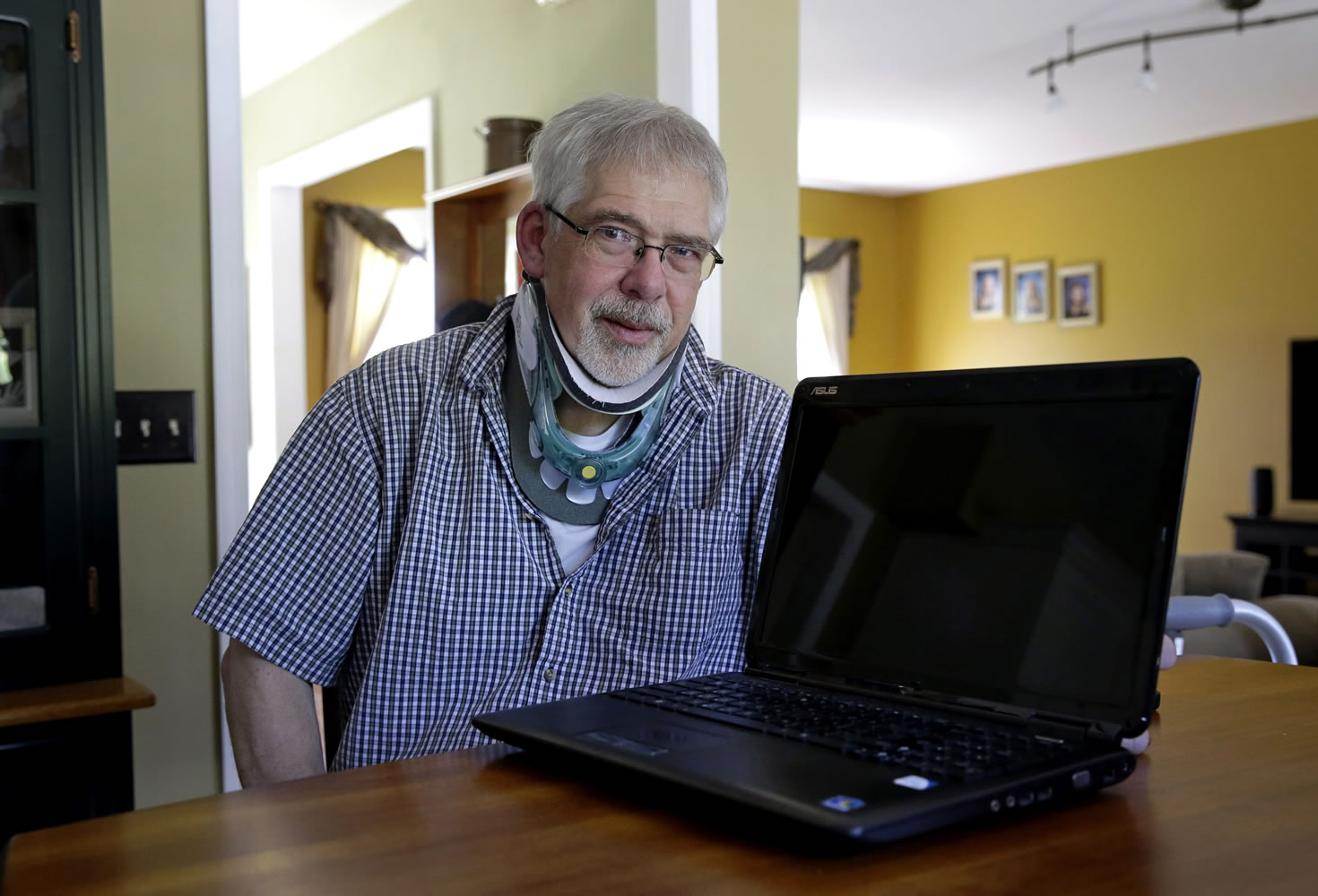 Mark Matulaitis, who has had Parkinson's disease since 2011, uses his laptop computer for virtual house calls with his neurologist from his home in Salisbury, Md.