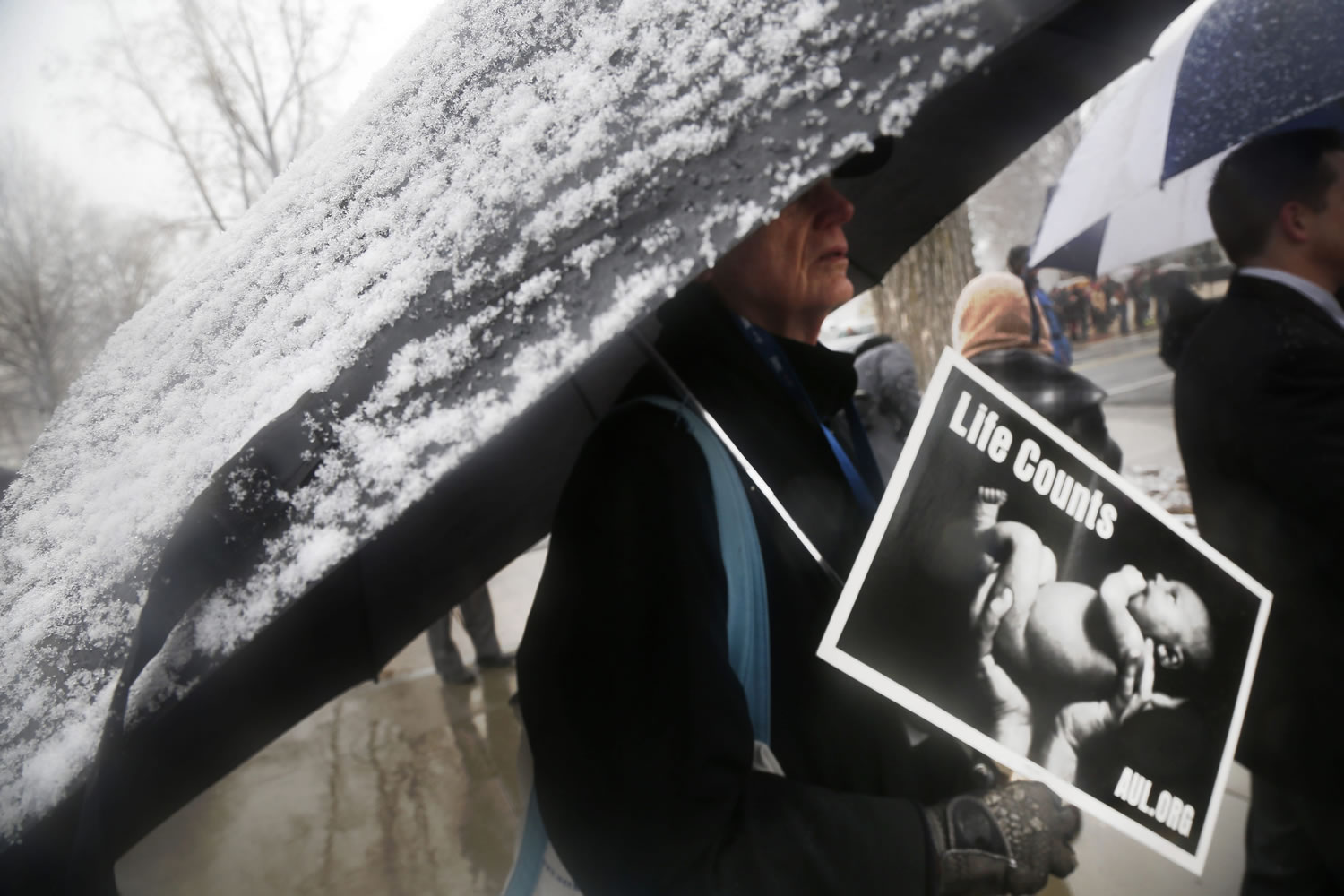 A protester stands as it snows during a demonstration in front of the Supreme Court in Washington on Tuesday.
