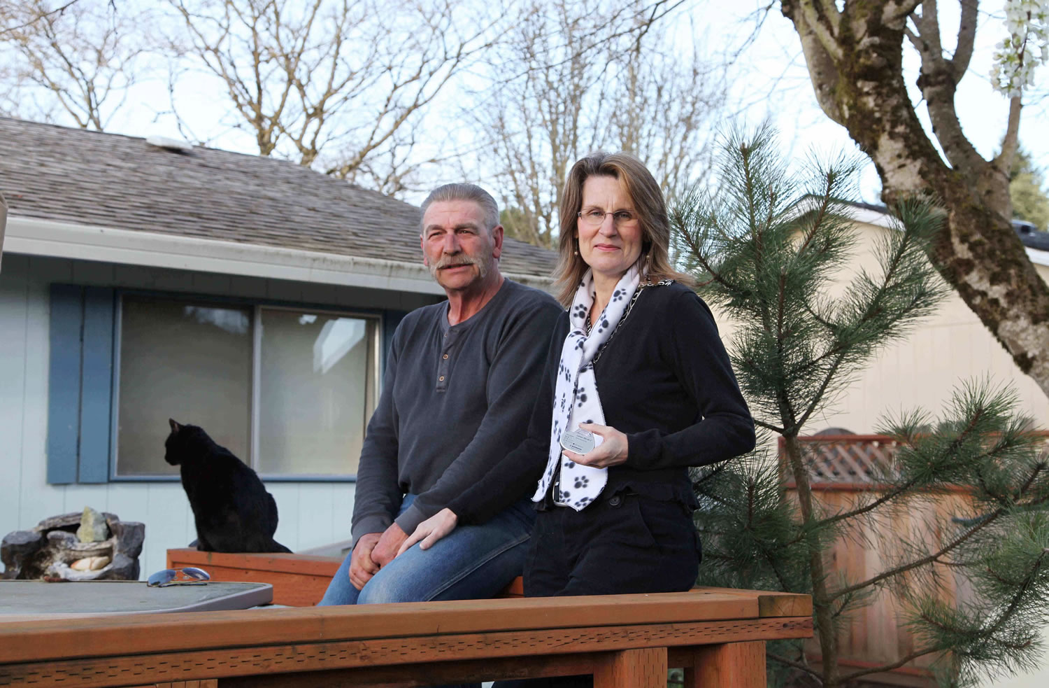 Michael and Diedre Gibbons sit on their porch in Aloha, Ore., on March 18. Diedre holds a pacemaker that's also implanted in her chest to help with congenital heart failure.