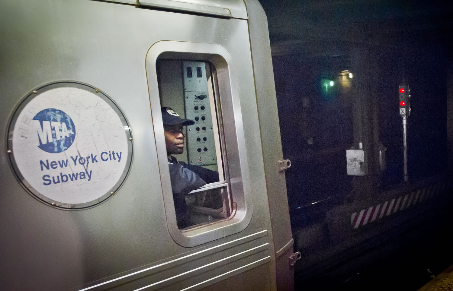 A Metropolitan Transit Authority subway train operator waits for red-light signal, controlled by a manual subway interlocking switch and signal system, to go green Wednesday in New York.