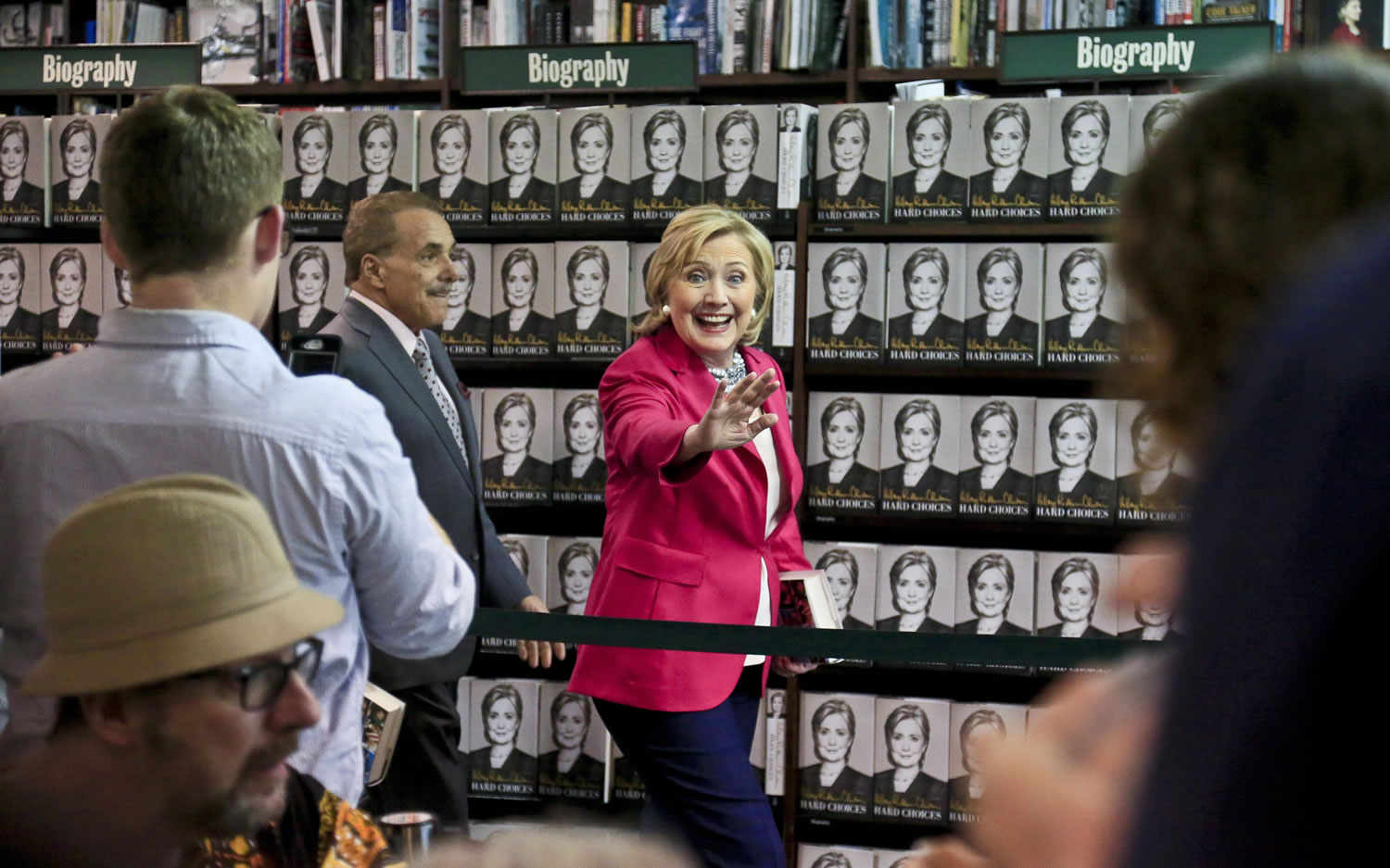 HiIlary Rodham Clinton, center, waves to a gathering as she arrives for a book signing on Tuesday at Barnes and Noble bookstore in New York.