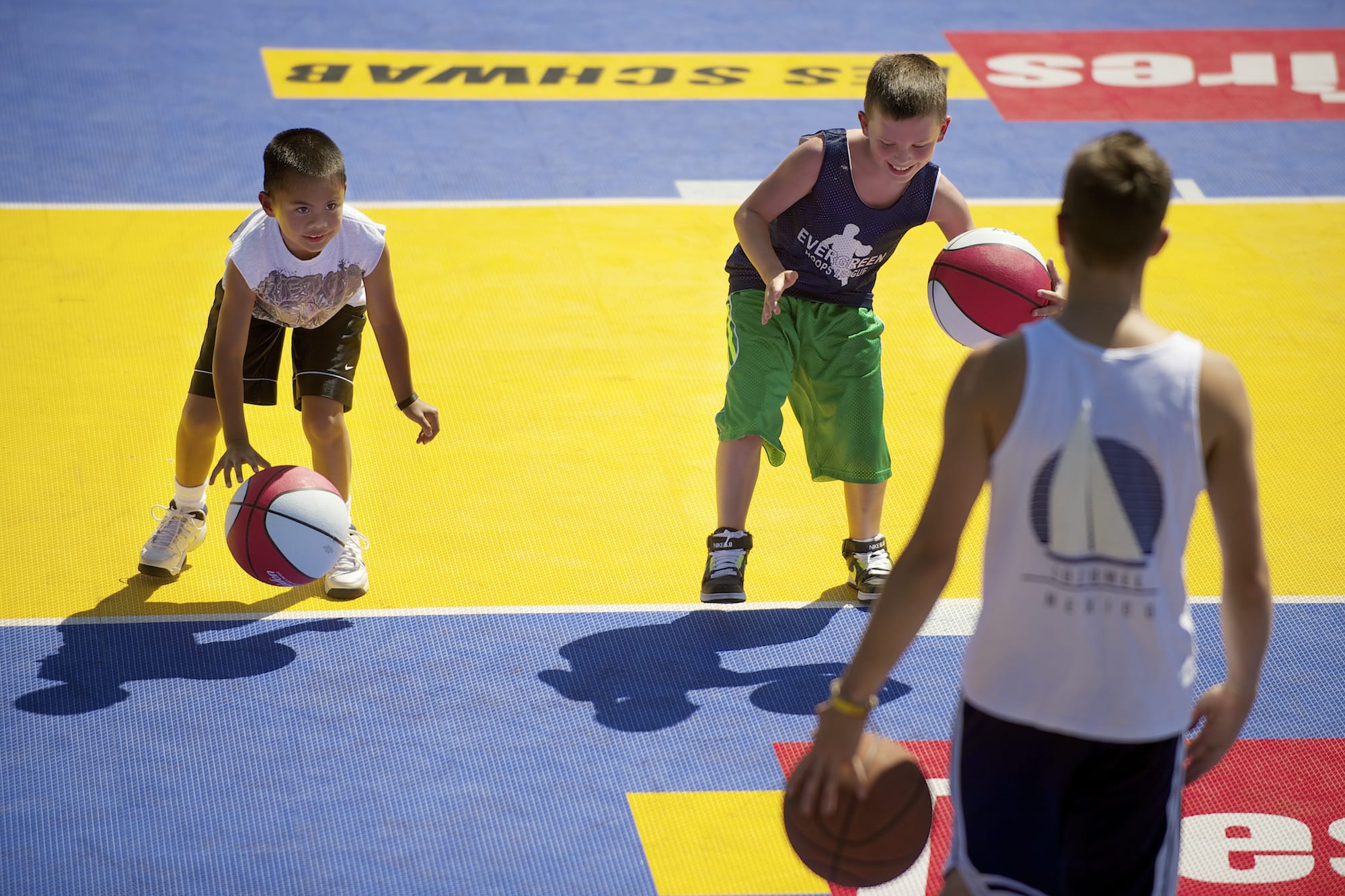 Eric Albios, 8, left, of Vancouver, and Keoni Jones, 9, of Vancouver, practice dribbling skills Friday August 17, 2012 at a kids clinic as part of the kick off for the weekend-long Hoops on the River, a 3-on-3 basketball tournament.