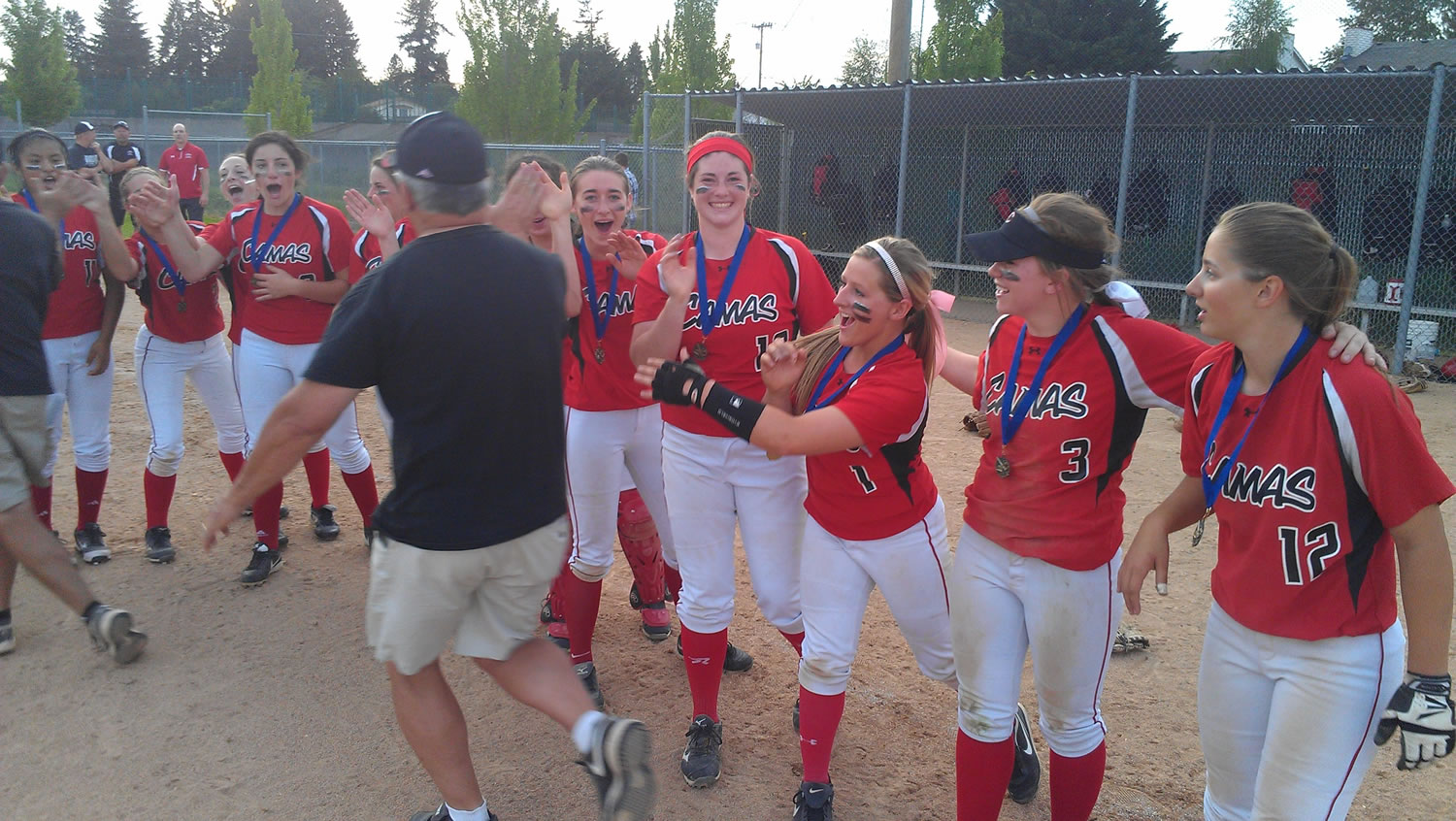 Camas players and coaches celebrate their district softball title