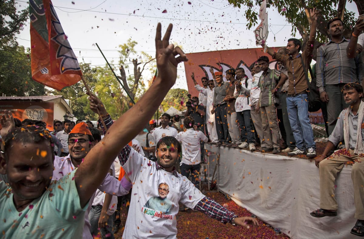 Bharatiya Janata Party supporters dance to celebrate preliminary results that showed a BJP victory Friday outside the party headquarters in New Delhi, India.