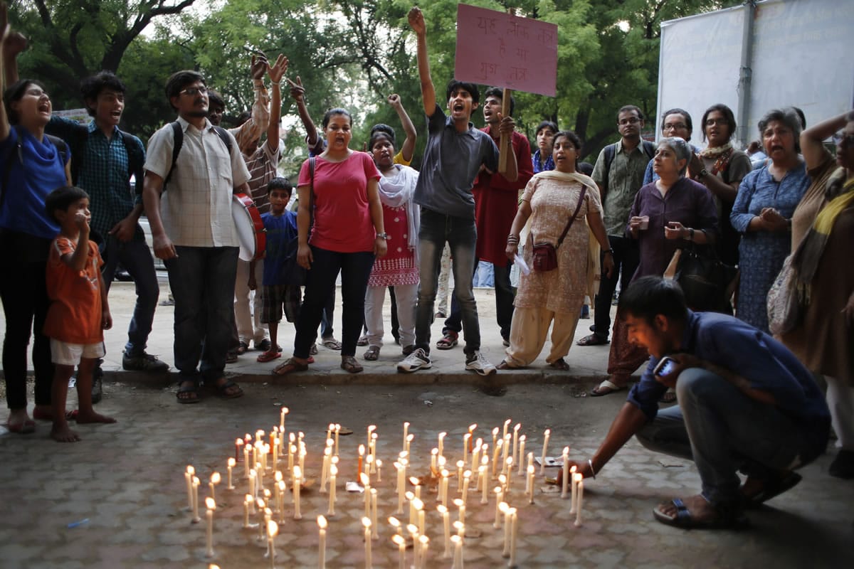 Activists shout slogans during a candle lit vigil to protest against the gang rape of two teenage girls, in New Delhi, India, Saturday. Police arrested a third suspect and hunted for two others Saturday in the gang rape and slaying of two teenage cousins found hanging from a tree in Katra village, in the northern Indian state of Uttar Pradesh, a case that has prompted national outrage.